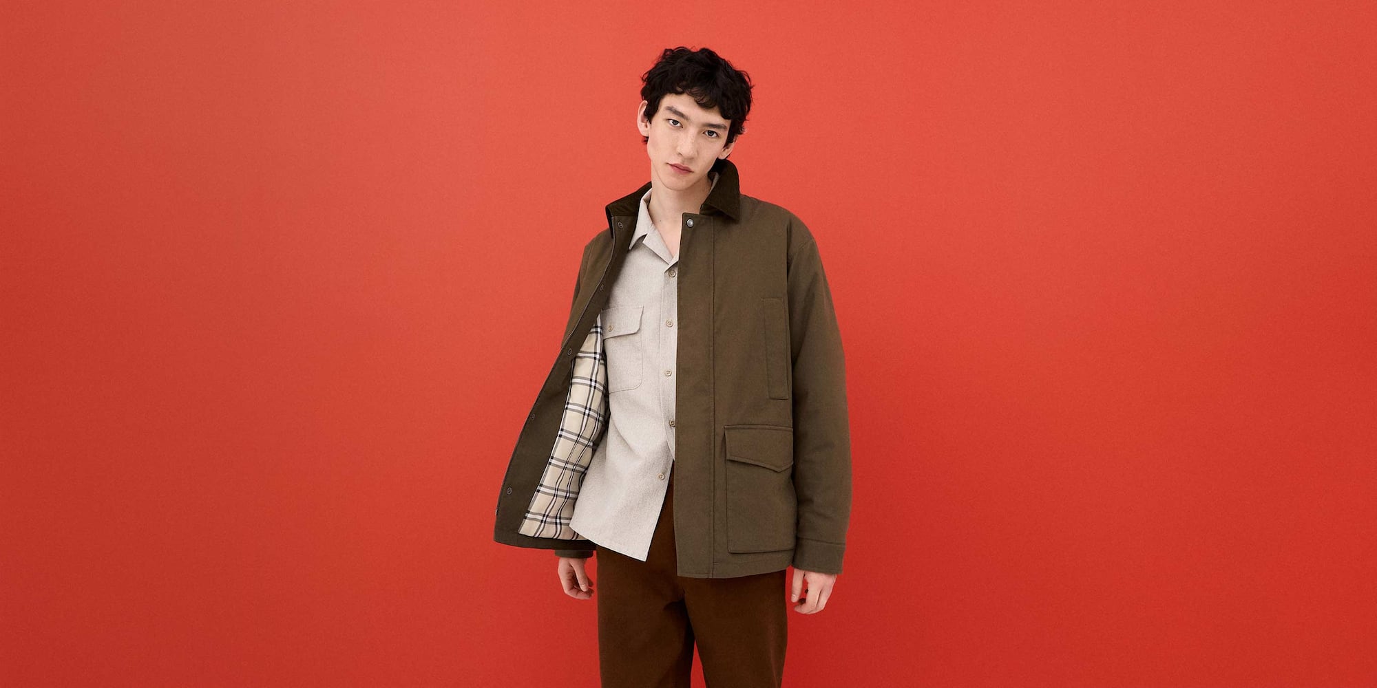 model wearing PUFFERTECH Utility Jacket in olive over a beige shirt and brown trousers