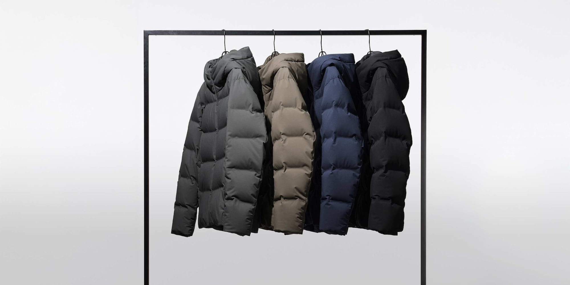 four Seamless Down Parkas hanging from a rail