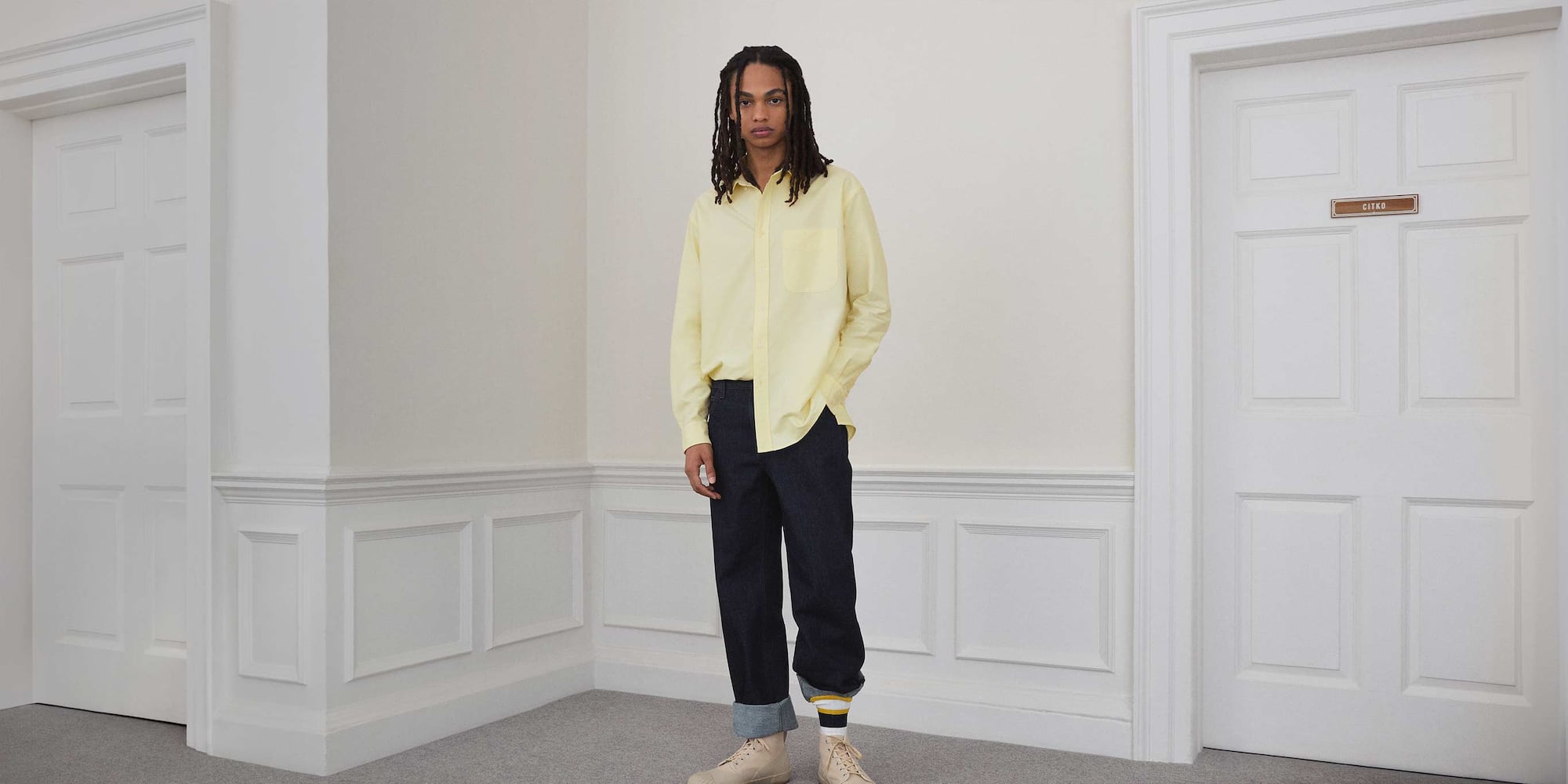 model wearing Straight Jeans in blue with a yellow shirt, beige trainers and white, yellow and navy striped socks