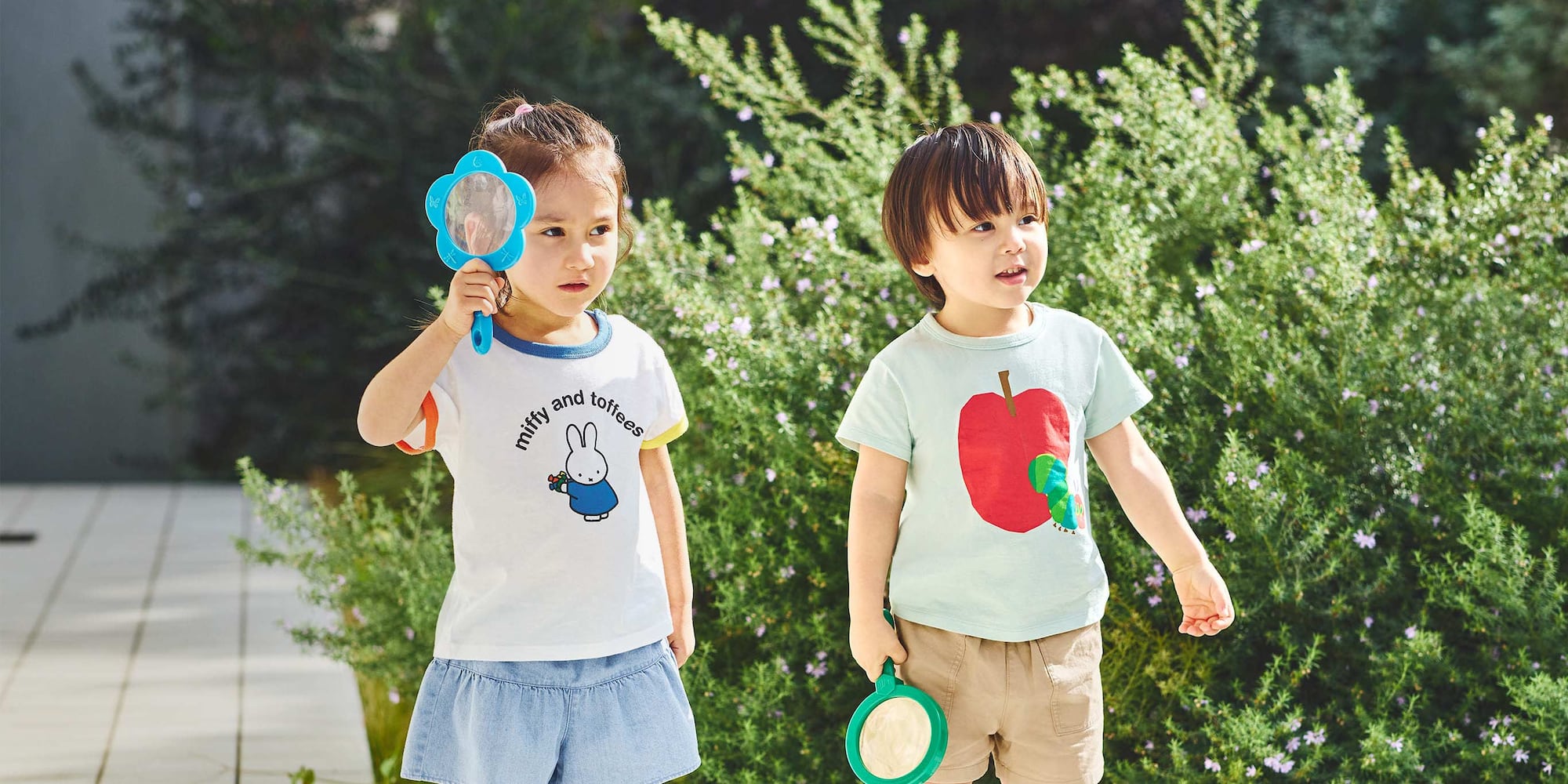 Zwei Models tragen T-Shirts der Kollektion mit miffy und der kleinen Raupe Nimmersatt.