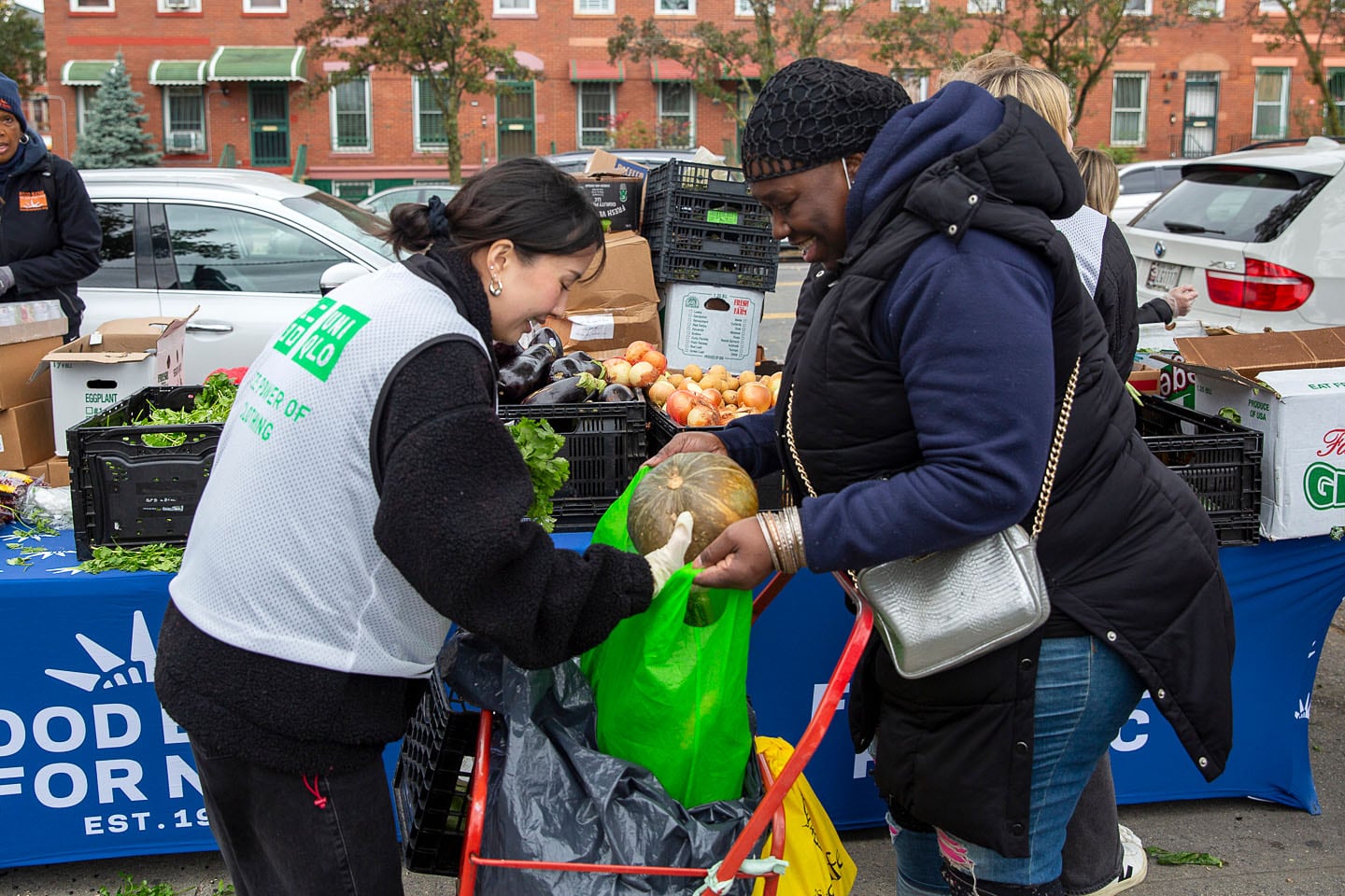 UNIQLO volunteer and local resident in NY helping put round squash into an eco bag.