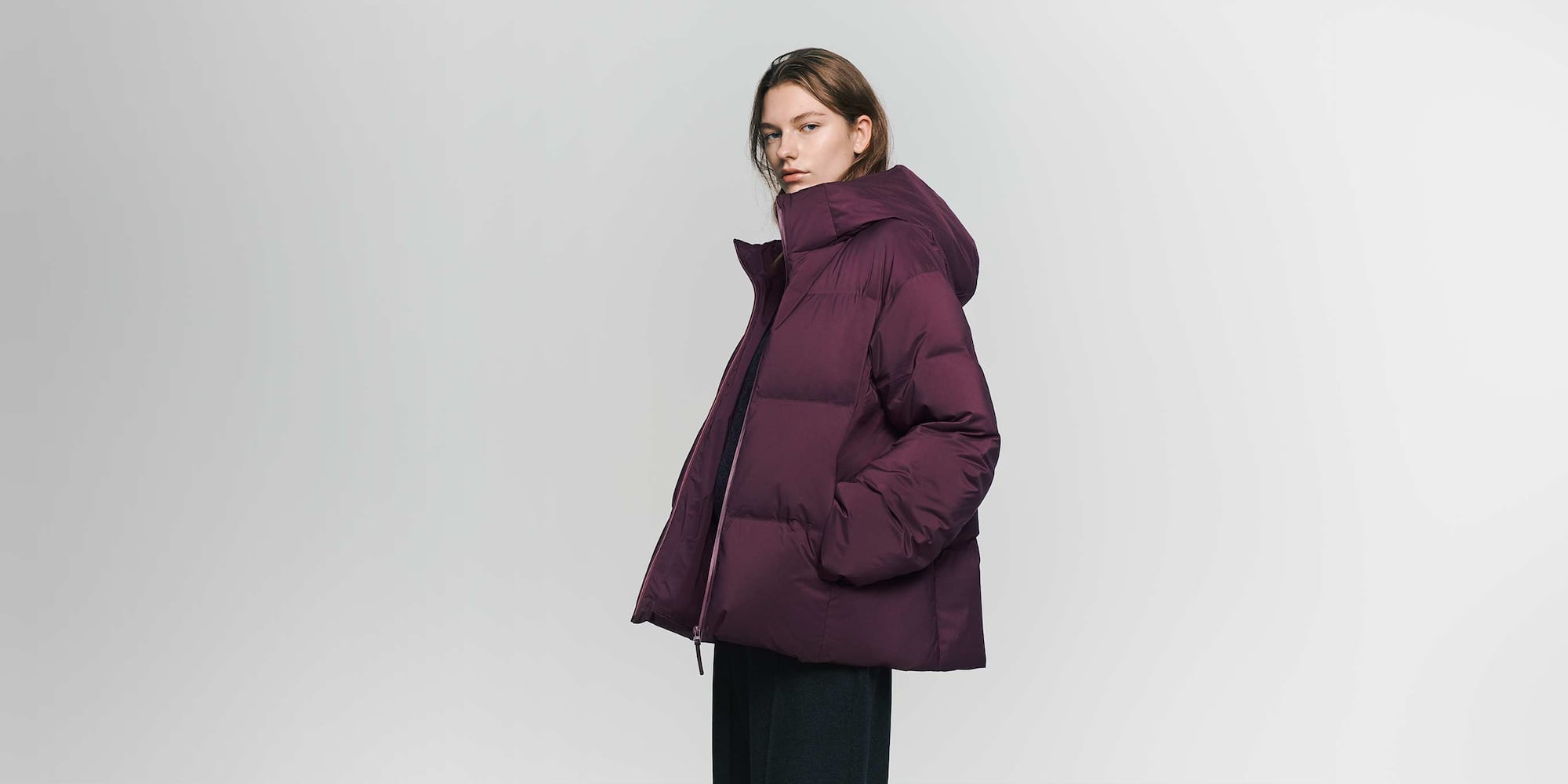 a model wearing a burgundy Seamless Down Parka and black trousers
