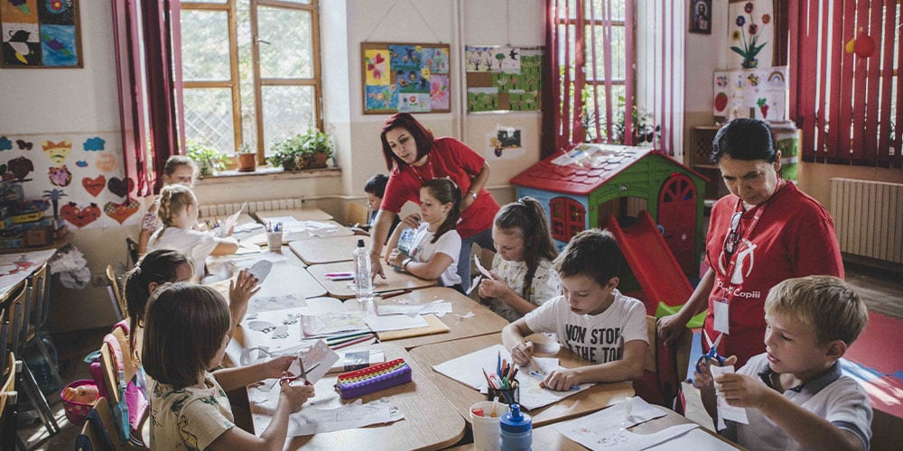 Credits to Save the Children organization for the photo. Volunteers leading kids' art workshop.