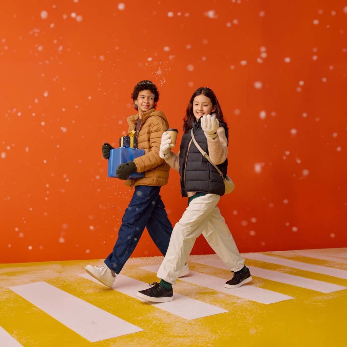 two models wearing UNIQLO Warm Lined Trousers while snow falls around them