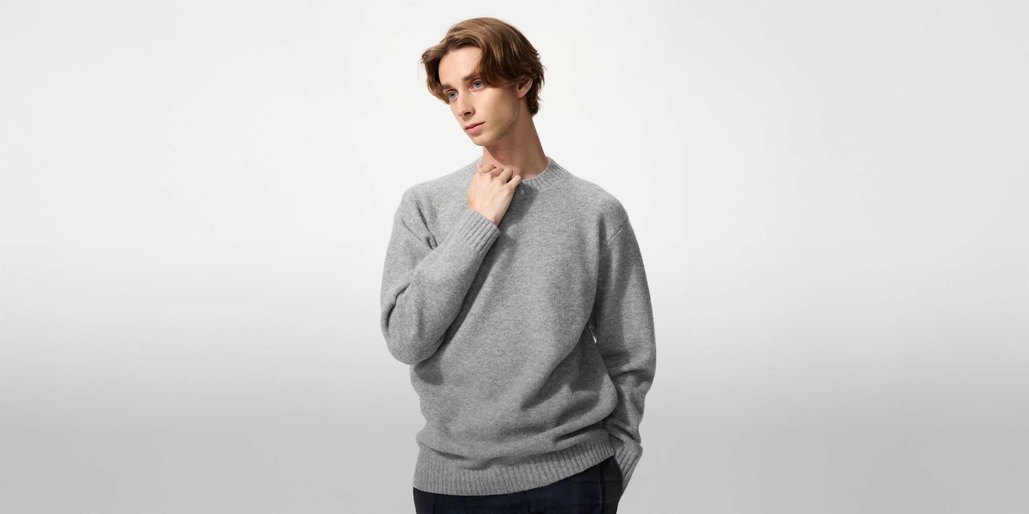 Model trägt einen grauen Pullover mit Rundhalsausschnitt aus Soufflé-Garn.