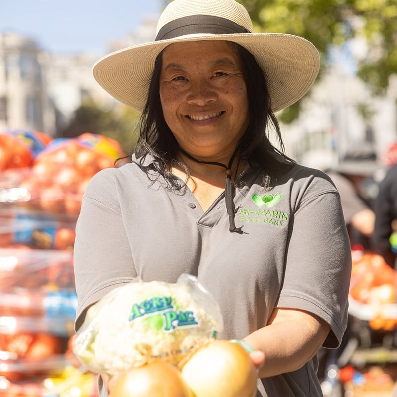 Woman holding up a bag of food and smiling