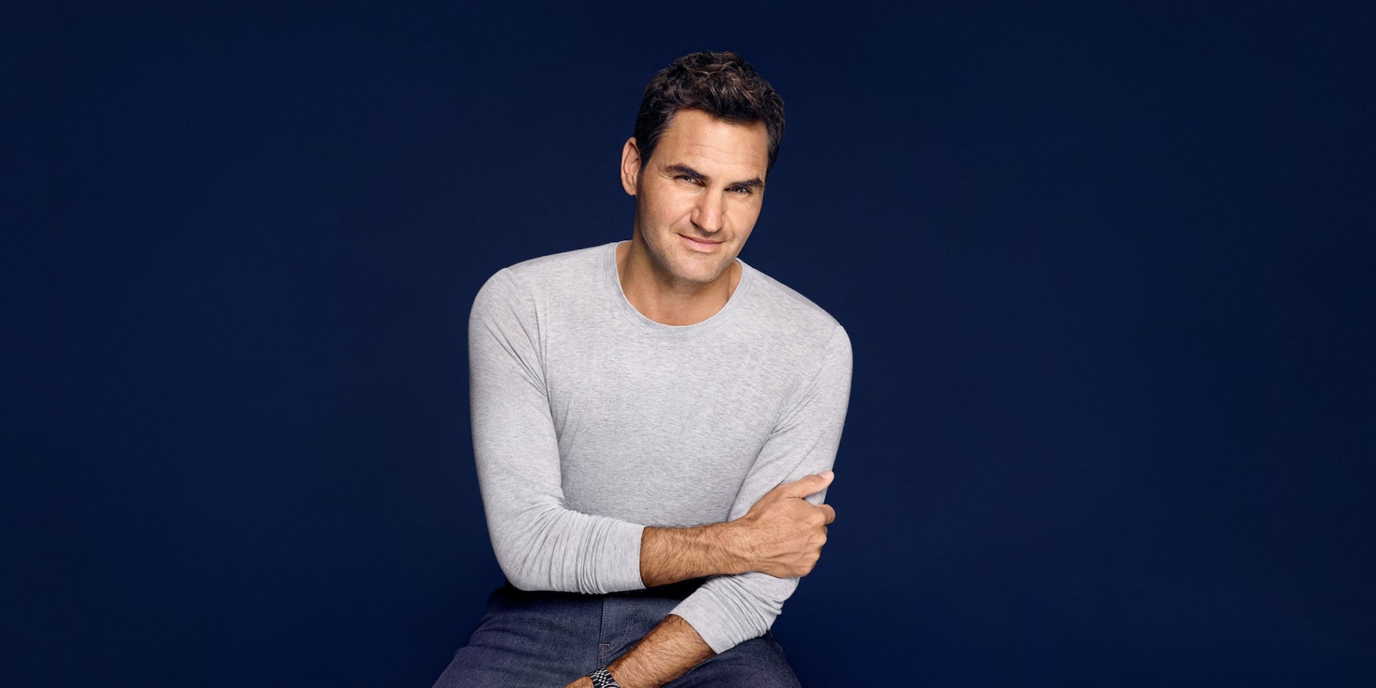 Roger Federer wearing HEATTECH Extra Warm Cashmere Blend Crew Neck T-Shirt in grey with dark wash jeans