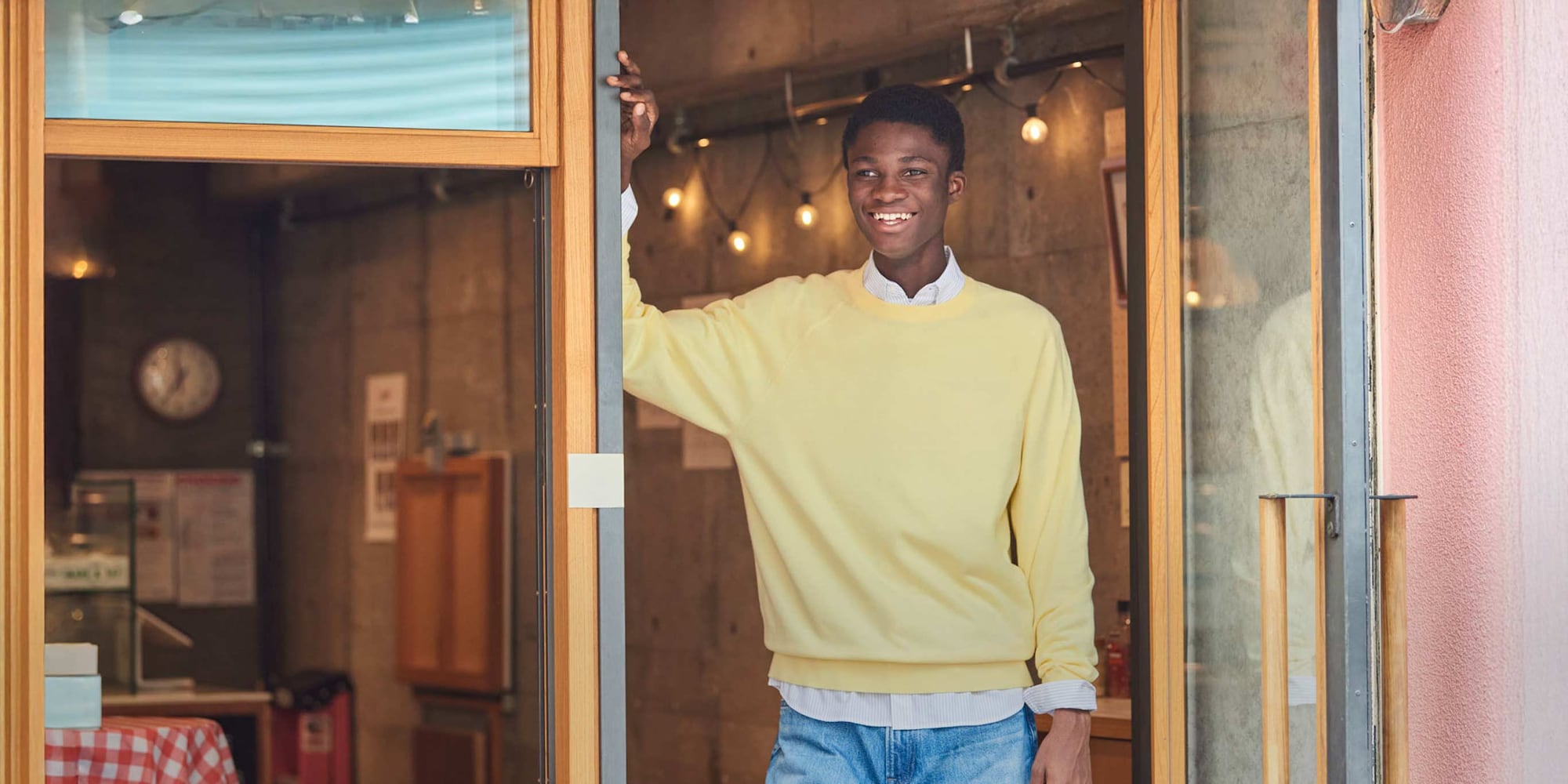 models wearing Washable Cotton Crew Neck Jumper in yellow over a striped shirt with mid wash jeans
