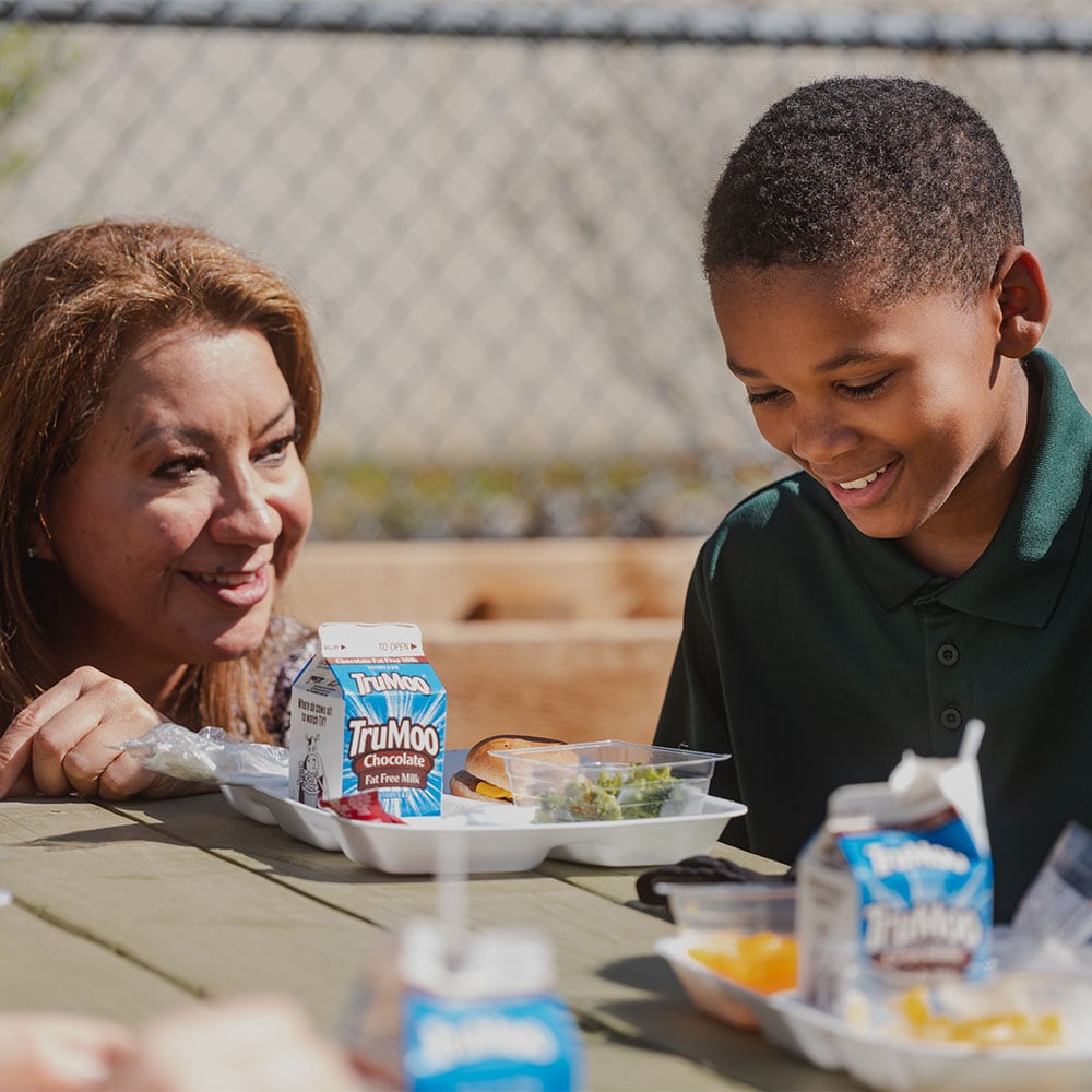 Woman and child holding food and smiling