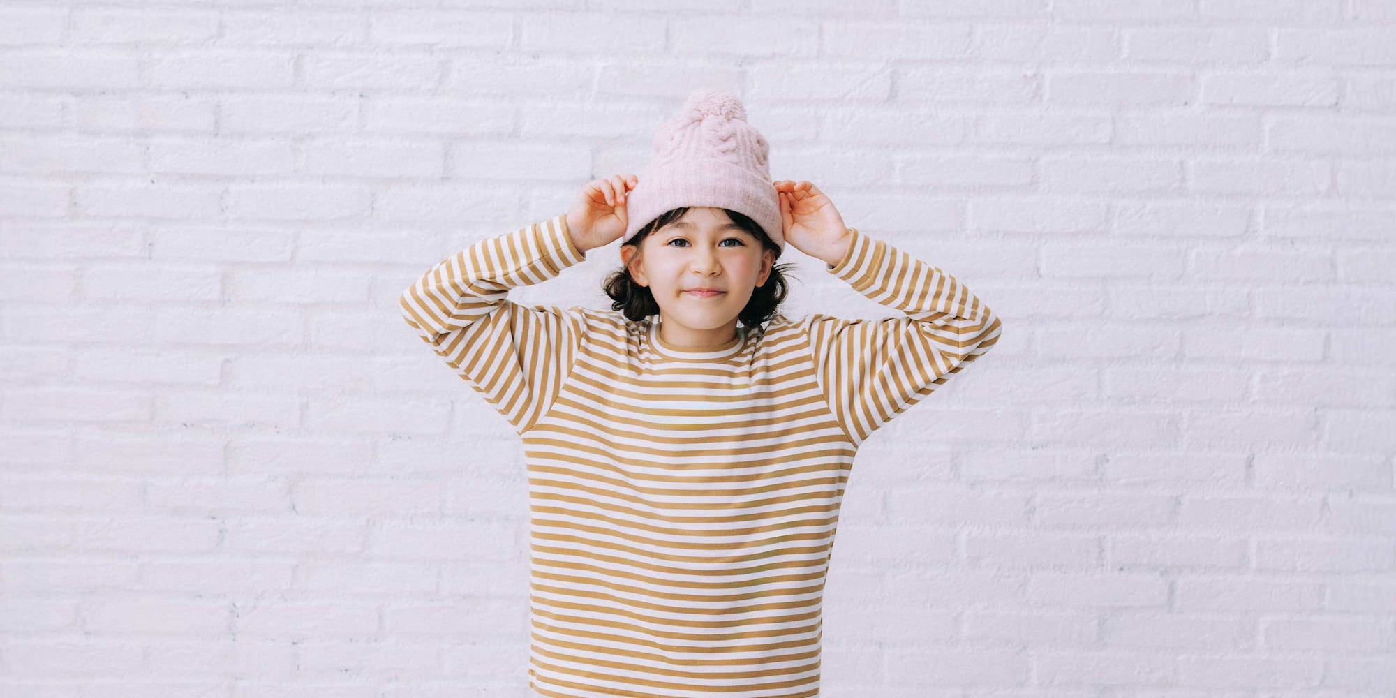 model wearing HEATTECH Knit Beanie Hat in red with a white T-shirt, fair isle knit jumper and off white fleece