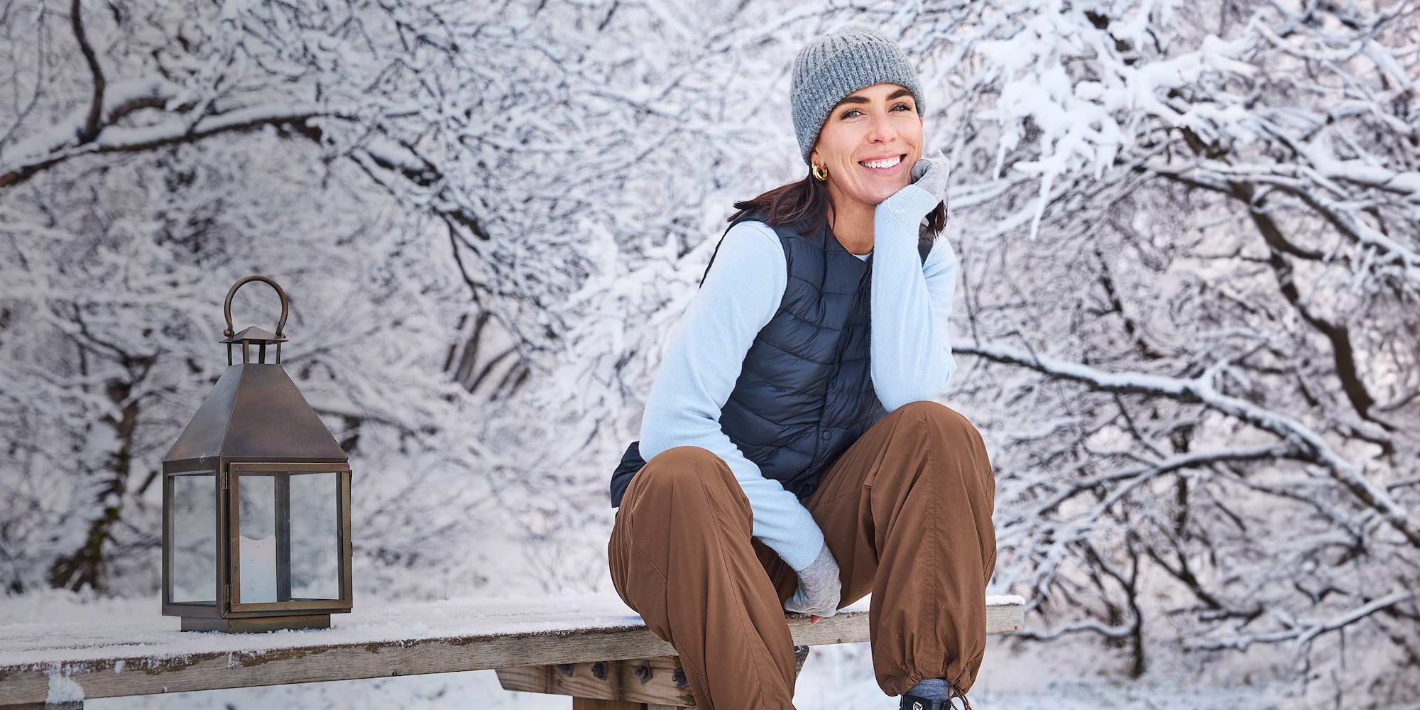 @_jessicaskye wearing Warm Lined Trousers in brown with a grey beanie, light blue jumper, navy quilted vest and grey gloves