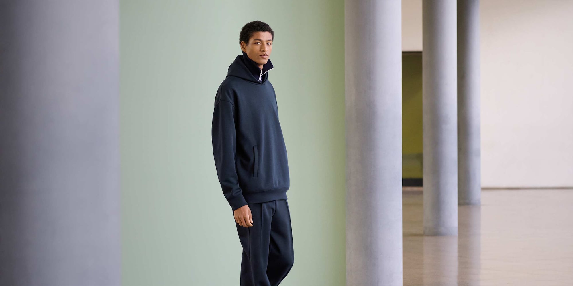 model wearing Oversized Sweat Full-Zip Hoodie in navy over a navy funnel neck zip-through top with navy joggers