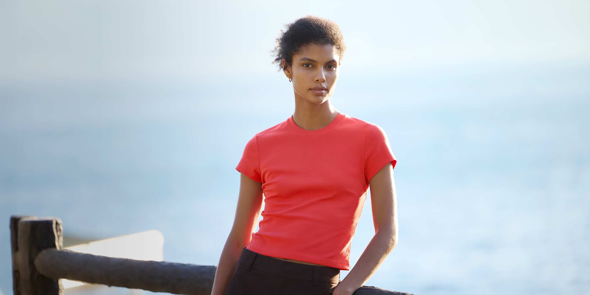 model wearing Mini T-Shirt in red with brown trousers and gold hoops