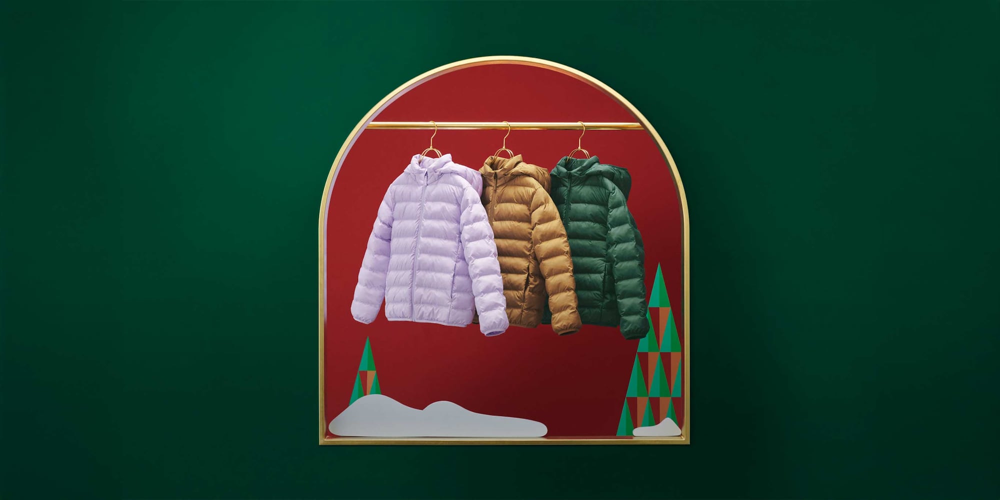 three PUFFERTECH jackets on a gold hanging rail against a background of red and green