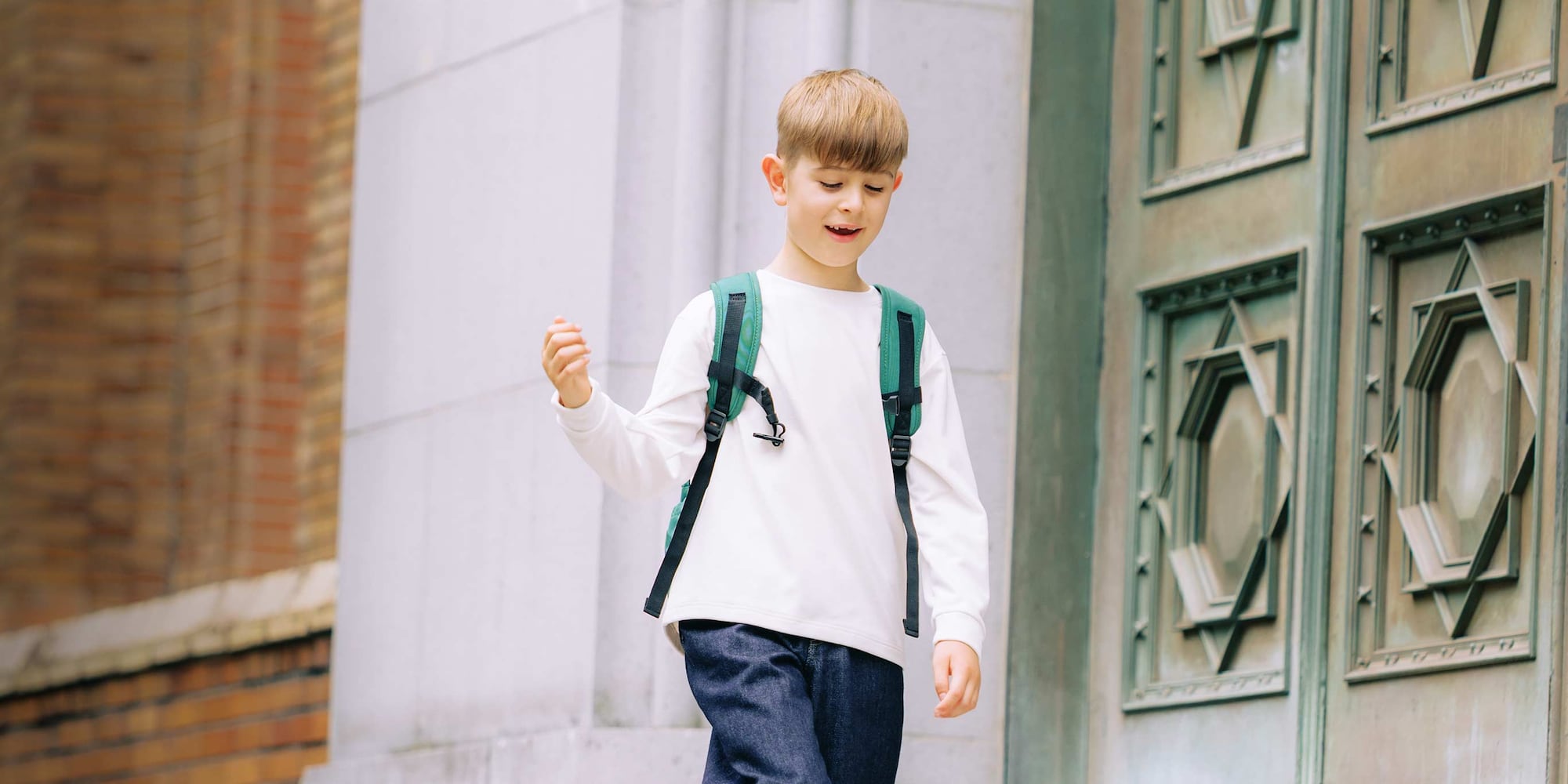 model wearing Fleece Crew Neck T-Shirt in off white with jeans and a green rucksack