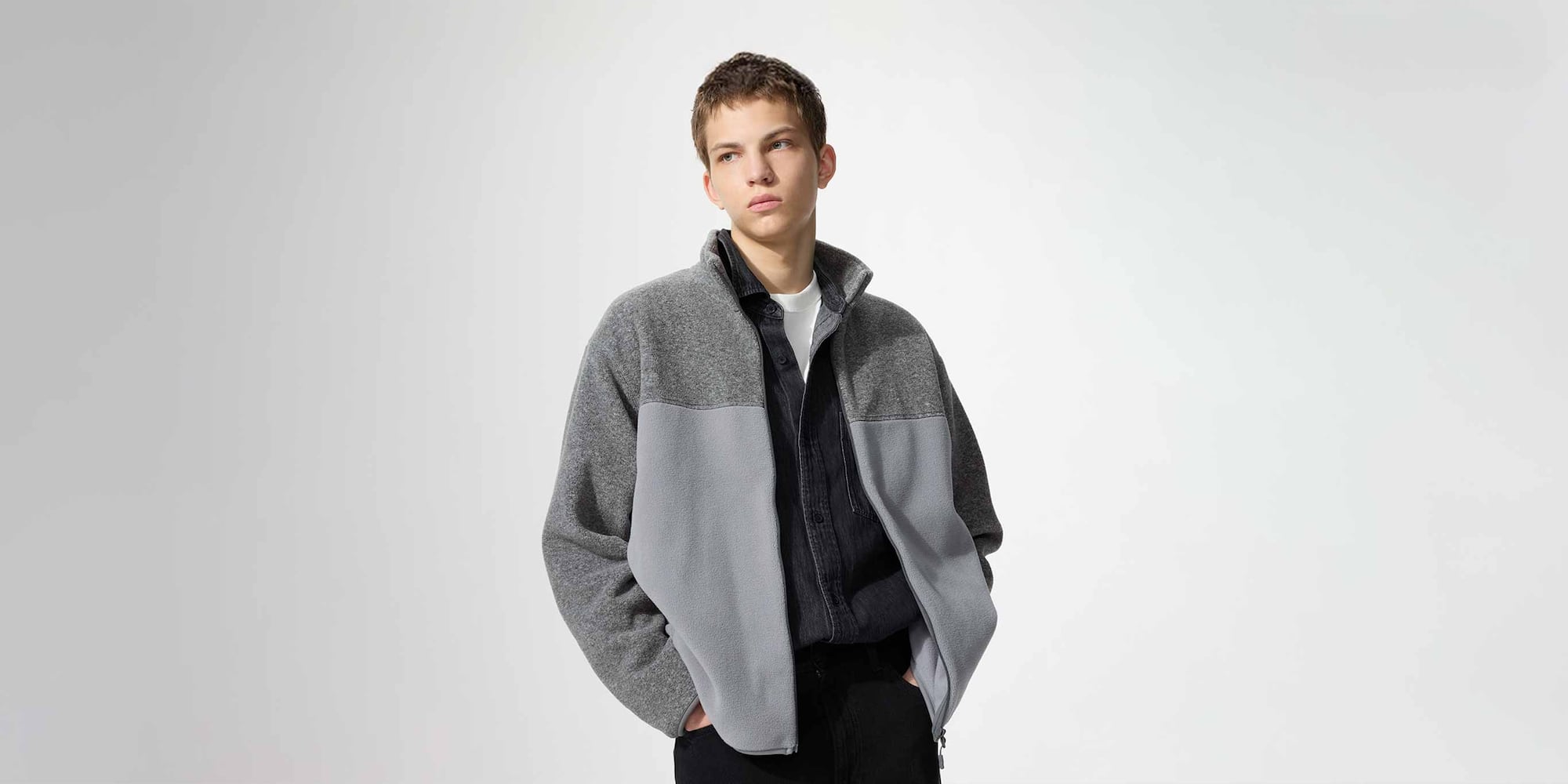 model wearing Fleece Full-Zip Jacket in dark green over a striped shirt, beige knit and blue jeans