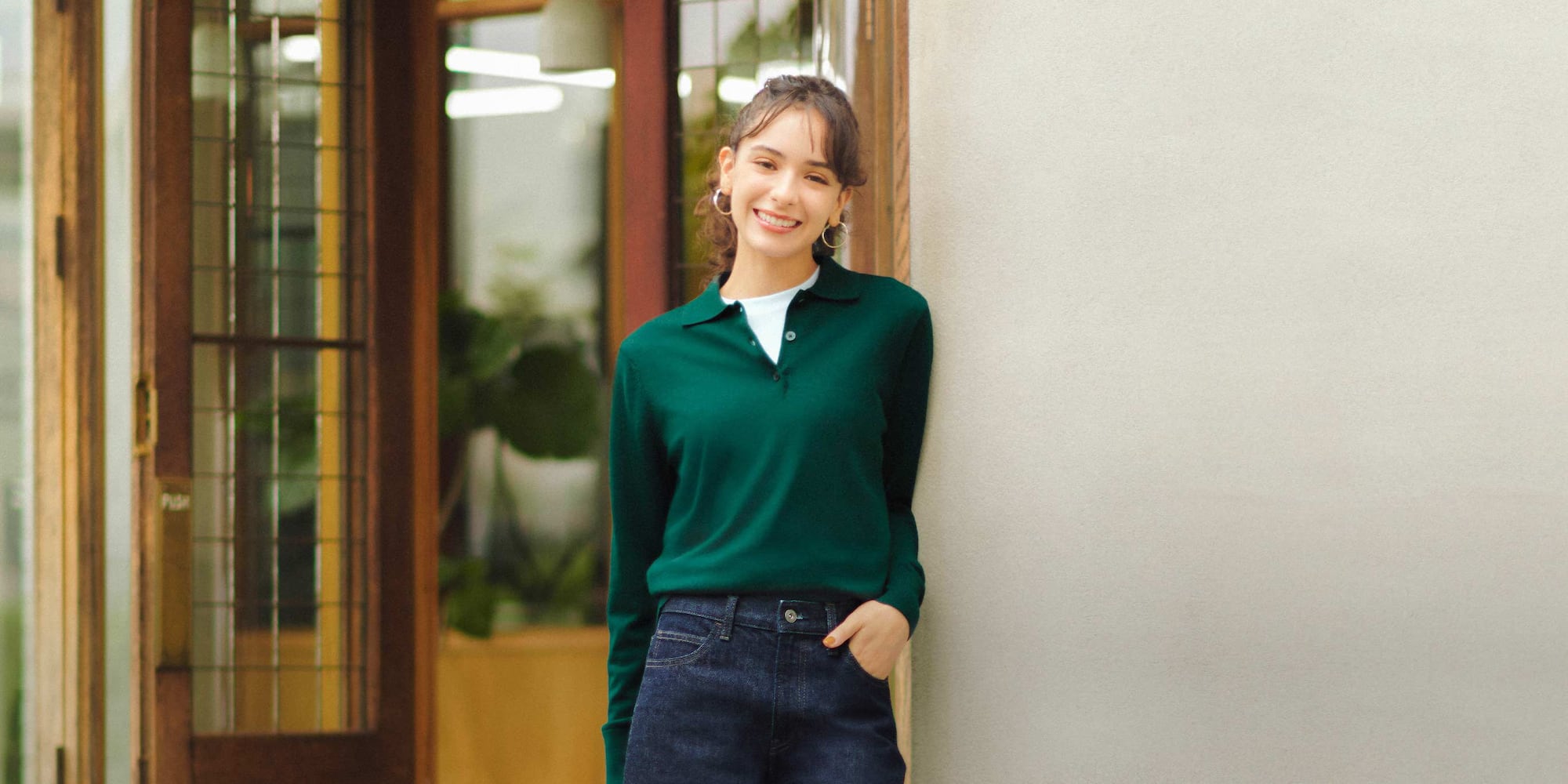 model wearing 100% Merino Polo Jumper in green over a white T-shirt with jeans