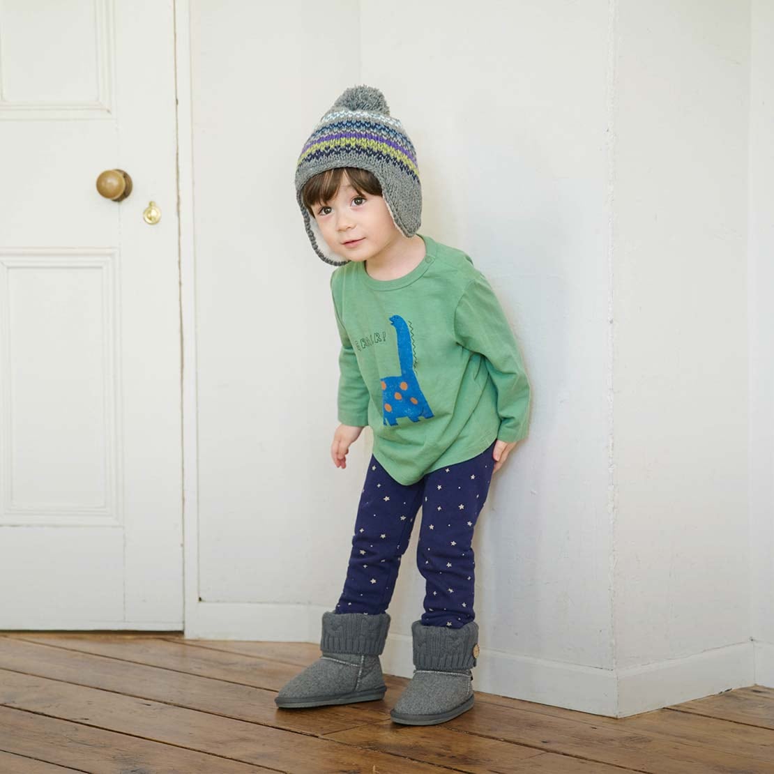 model wearing Fleece Leggings in navy with a star print with a long sleeved green T-shirt with a dinosaur