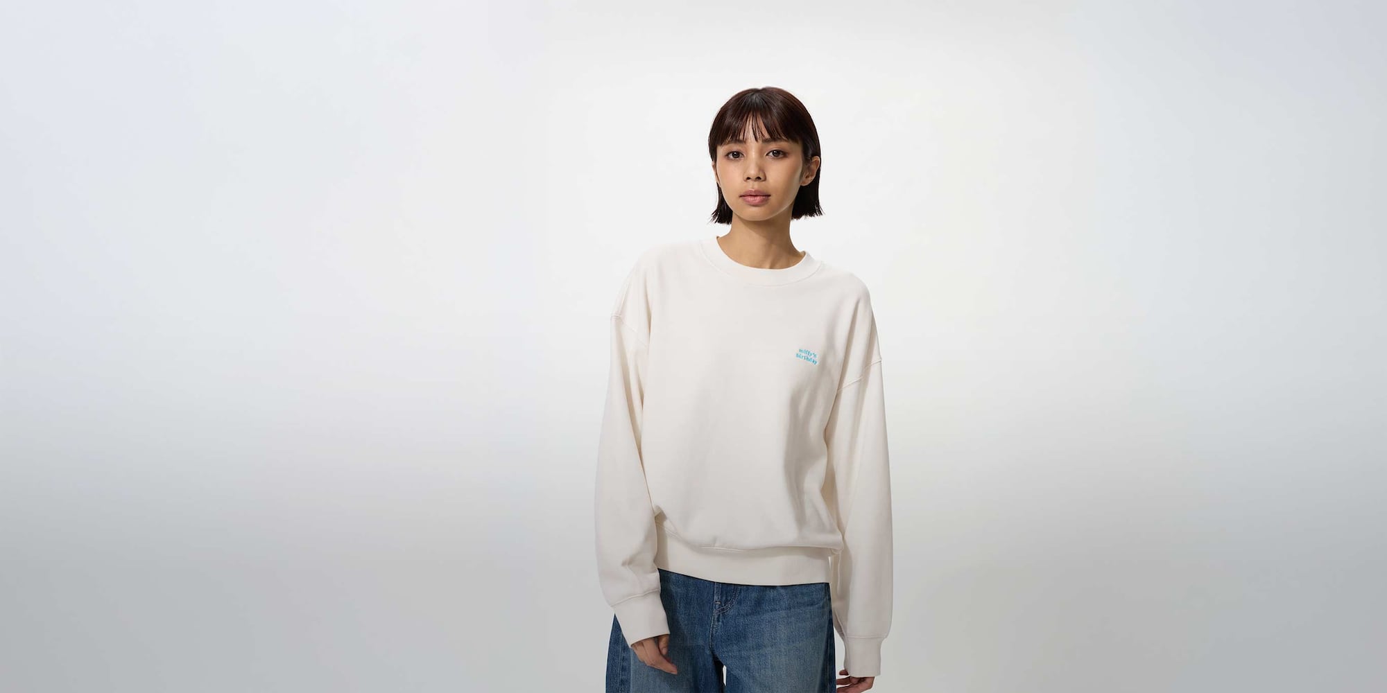 model wearing miffy in bloom UT Graphic Sweatshirt in pink with a black pleated skort