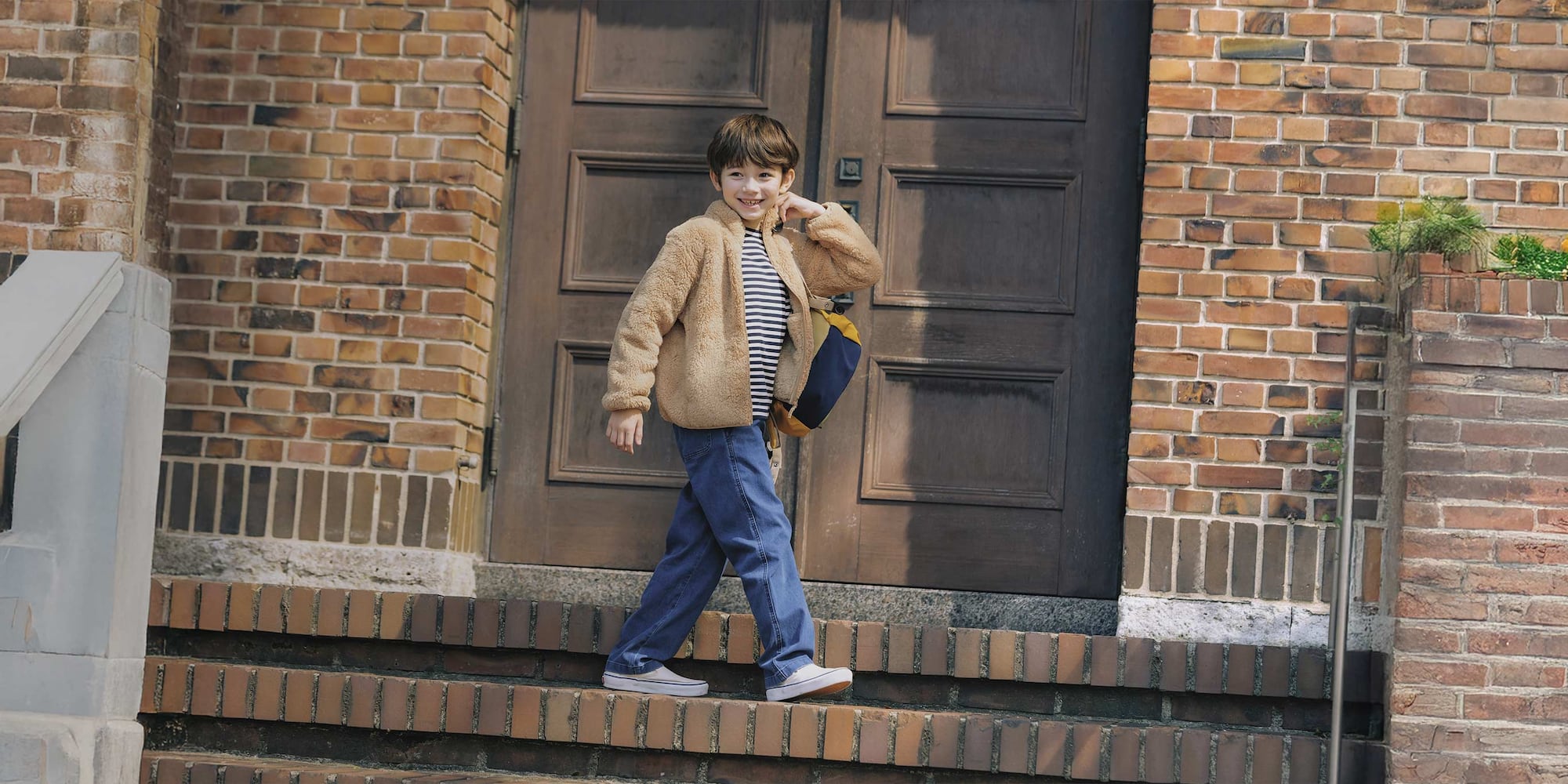 model wearing Easy Jeans in blue with a black and white striped top and beige fleece