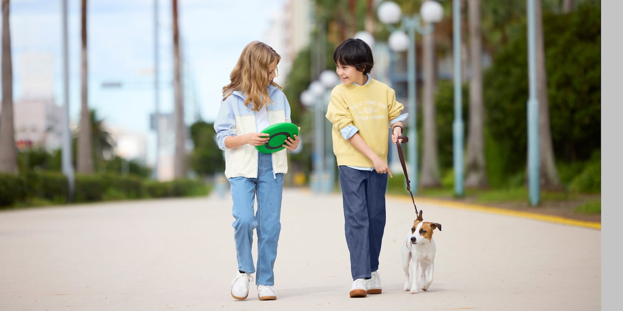 Bimbi con i Jeans Comodi Elasticizzati portano a spasso un cagnolino