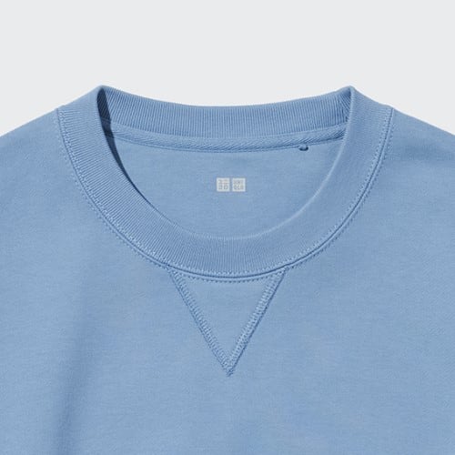Detail desain sweater klasik dengan tampilan modern, termasuk aksen rib dan V pada kerah.
