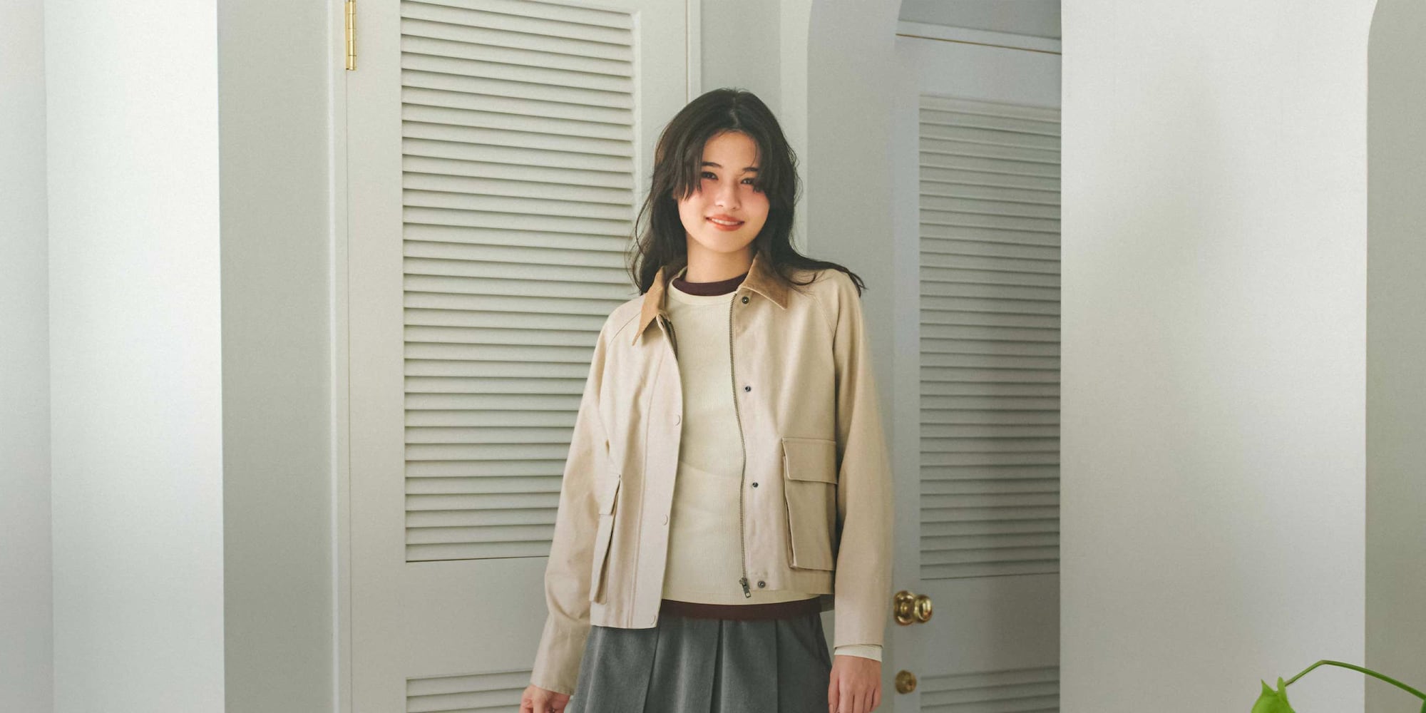 model wearing Utility Short Jacket in beige over an off white crew neck and grey skirt