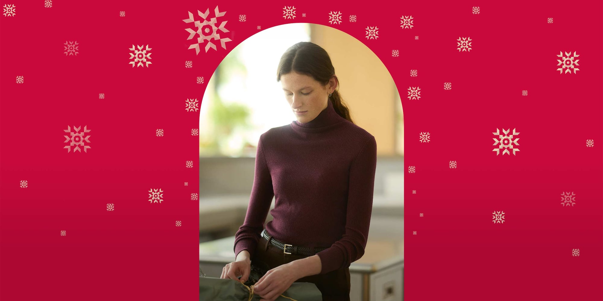 model wearing 100% Merino Ribbed Turtleneck Jumper in wine with brown trousers and belt