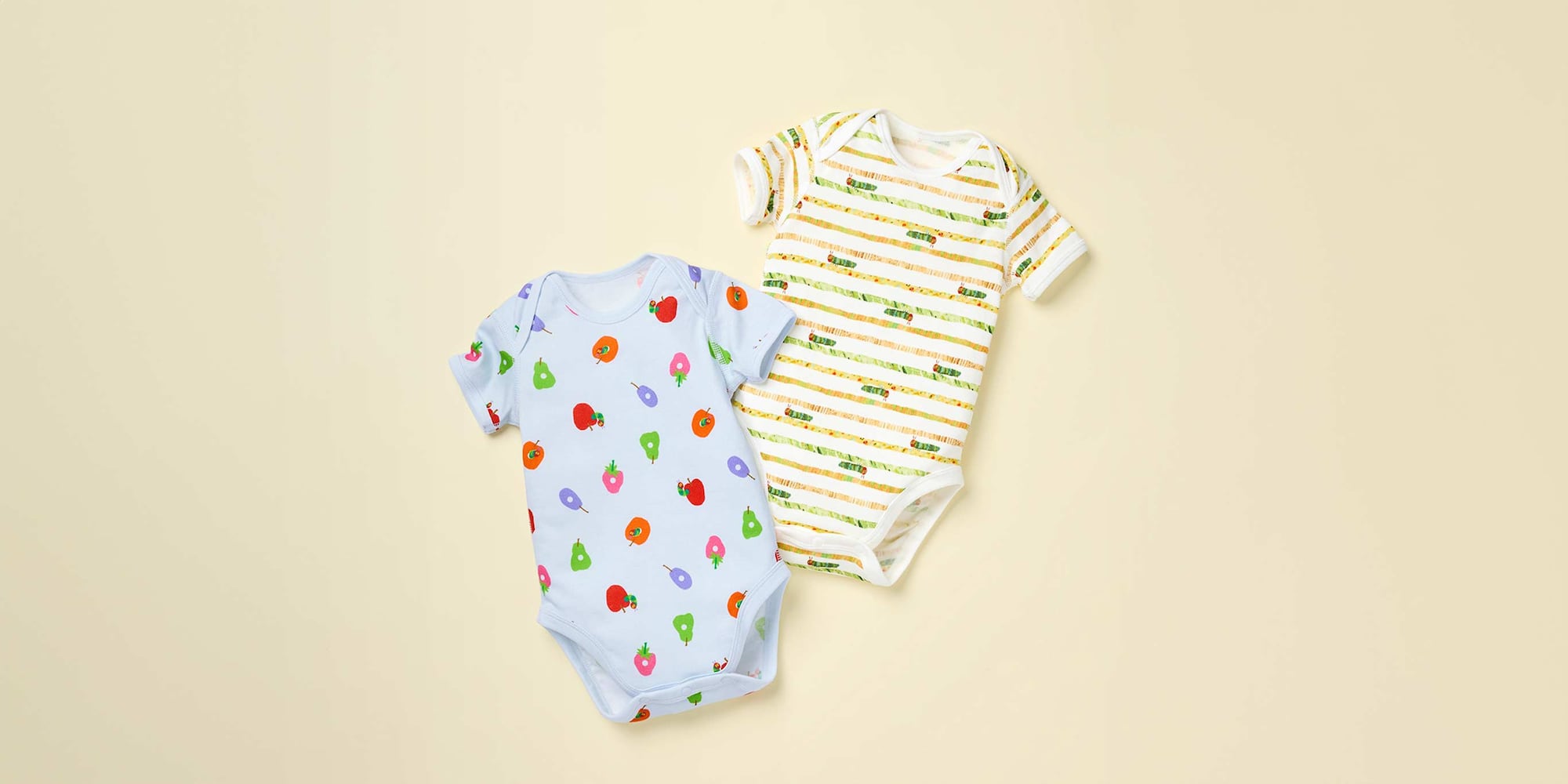 Zwei buntbedruckte Bodys in Hellblau und Weiß liegen nebeneinander.