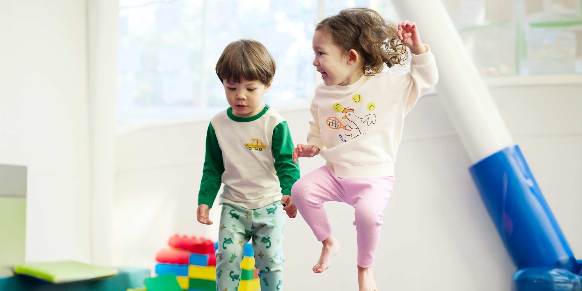 deux mannequins portant des vêtements UNIQLO pour tout-petits jouent