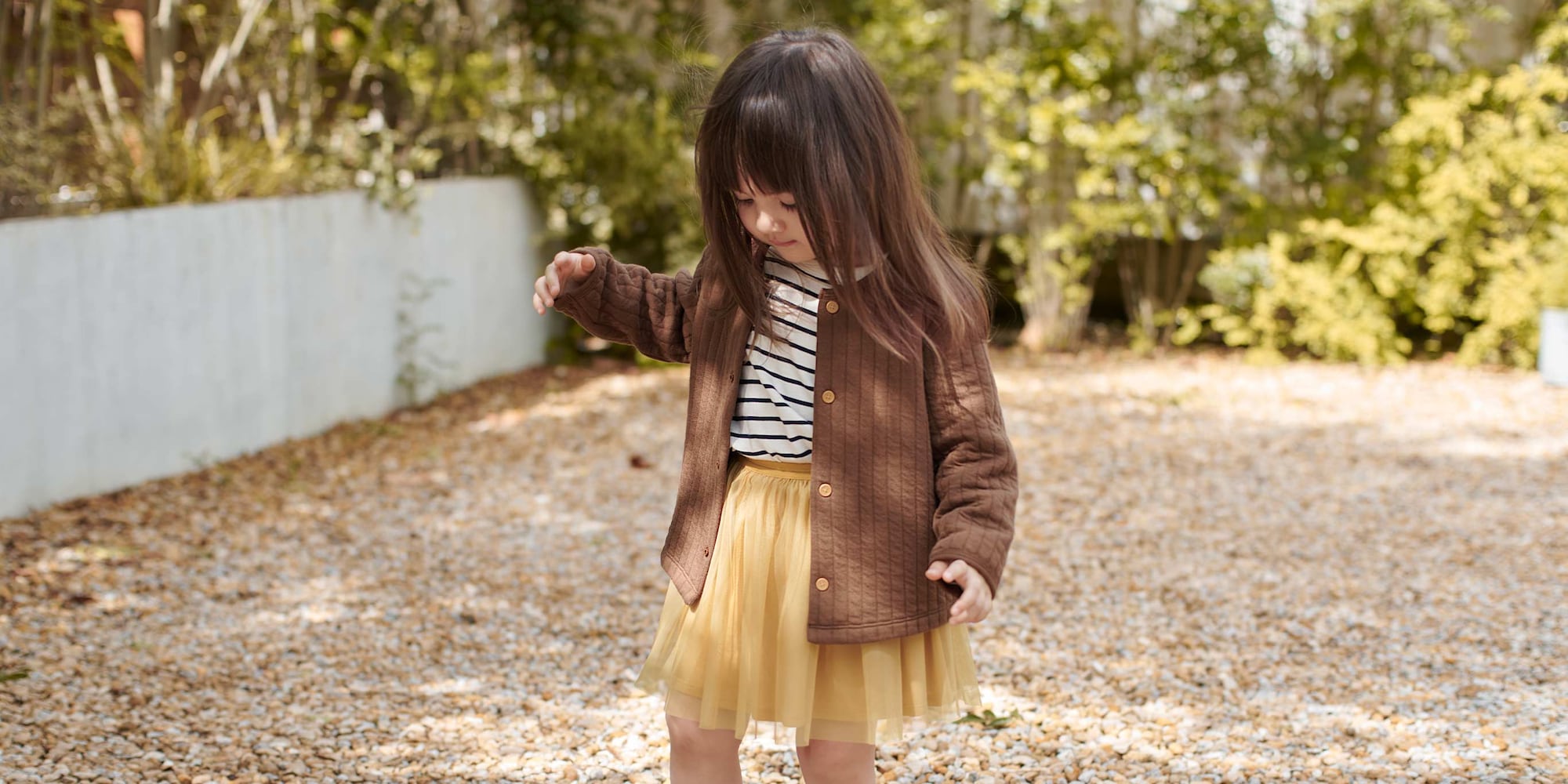 model wearing Quilted Cardigan in brown over a black and white striped top and yellow skirt