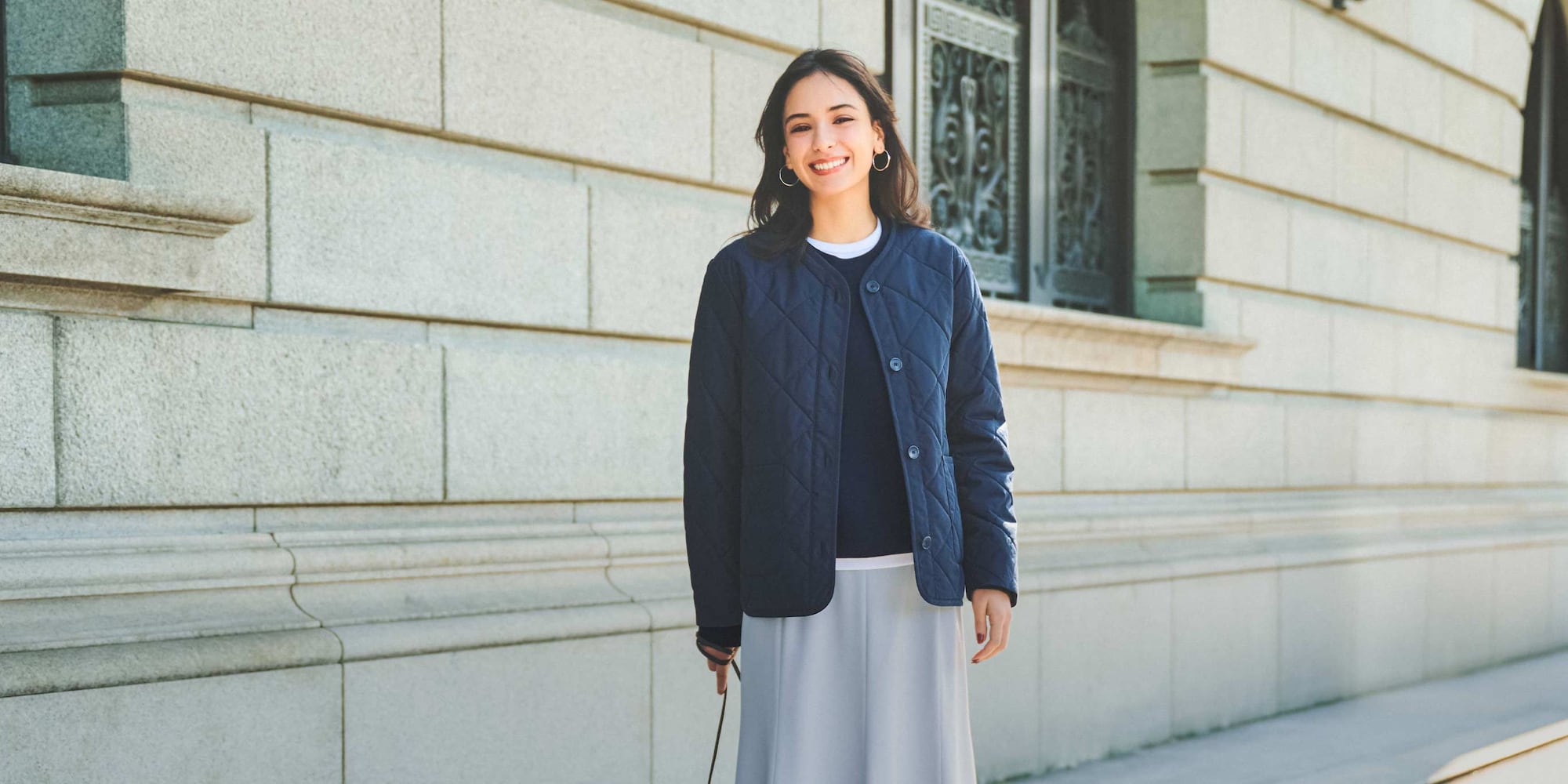 model wearing PUFFERTECH Collarless Jacket in navy over a white top and brown trousers with a green beanie