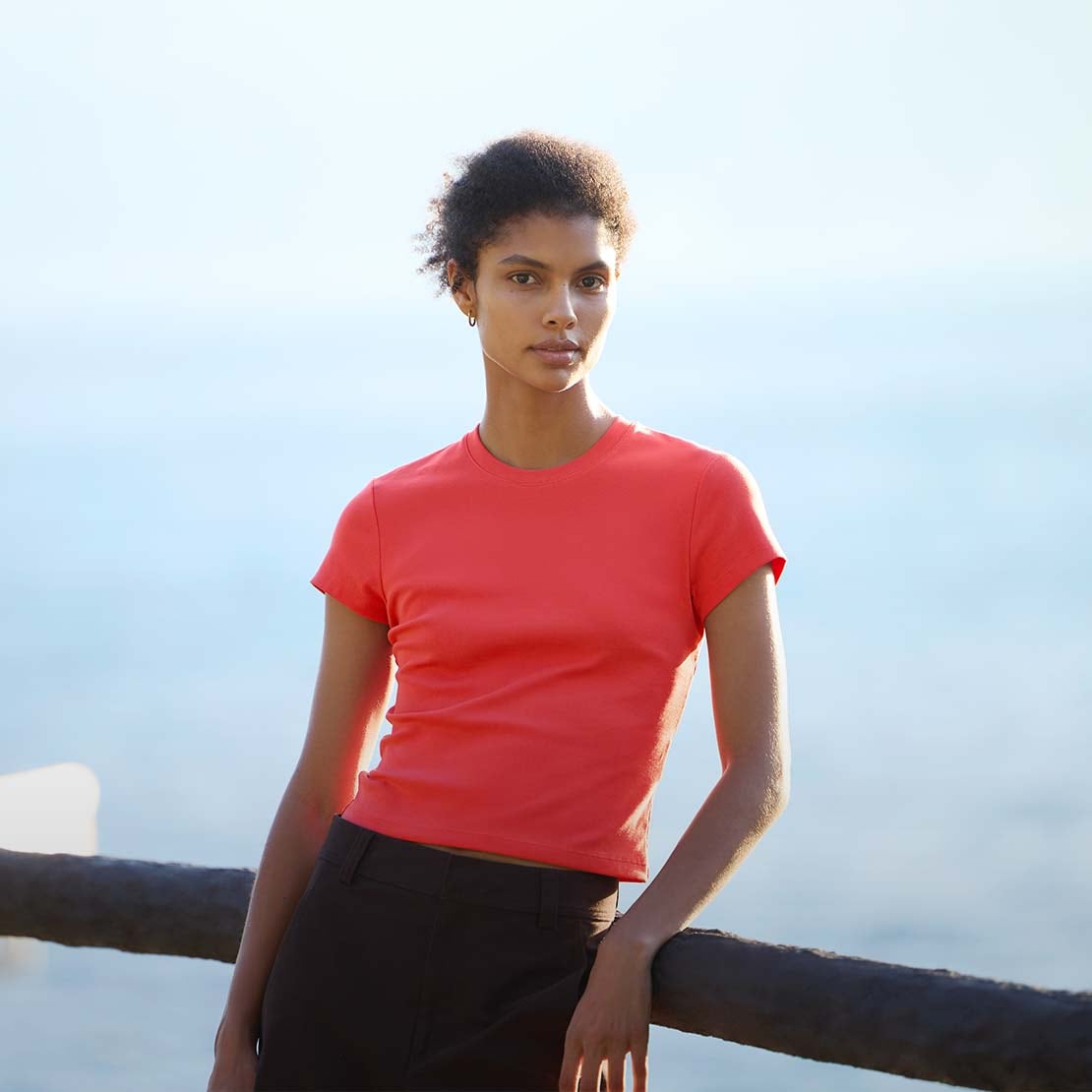 model wearing Mini T-Shirt in red with brown trousers and gold hoops