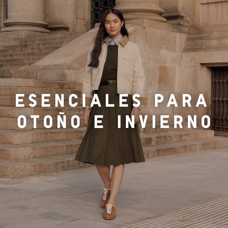 mujer con falda midi oscura y chaqueta beige