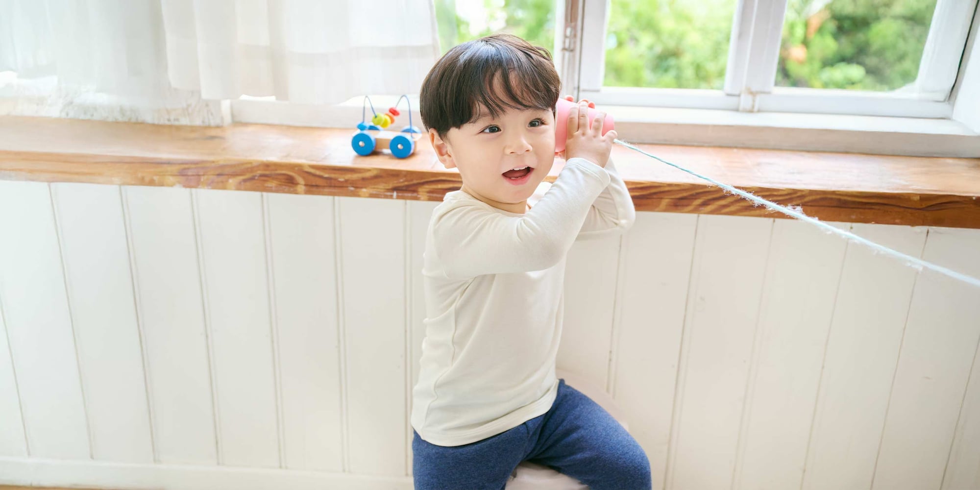 adult dressing a child wearing HEATTECH Cotton Crew Neck T-Shirt in off white as a base layer