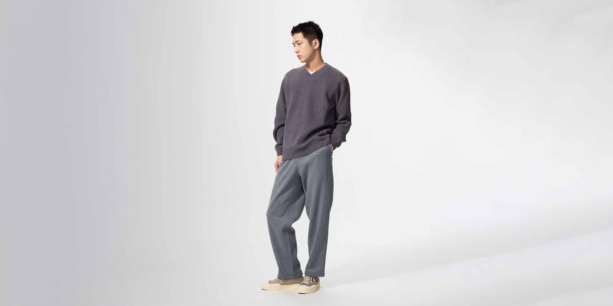 model wearing Knit Fleece Easy Ankle Trousers in dark grey with a dark grey knit