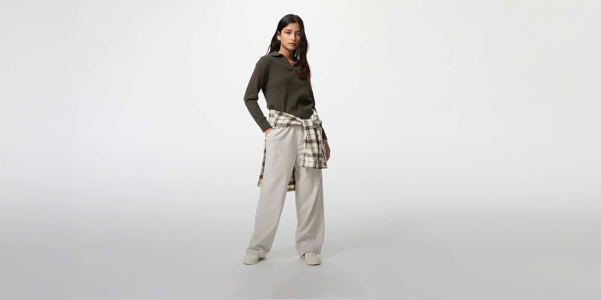 model wearing Flannel Trousers in light grey with a khaki jumper and checked shirt tied at the waist