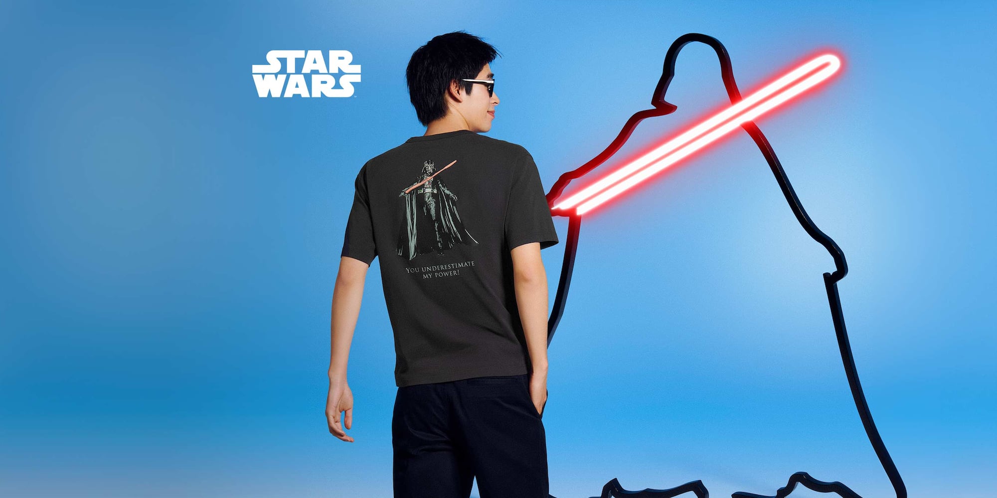 model wearing MAGIC FOR ALL Icons UT Graphic T-Shirt in dark grey showing darth vader and the words you underestimate my power on the back