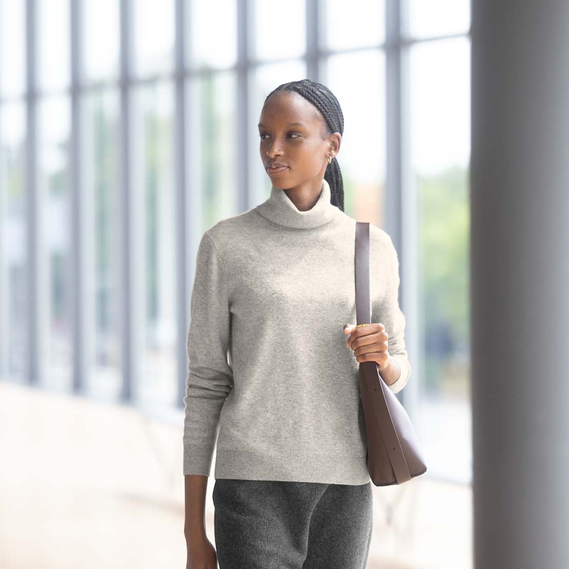 model wearing 100% Cashmere Turtleneck Jumper in grey with a brown shoulder bag