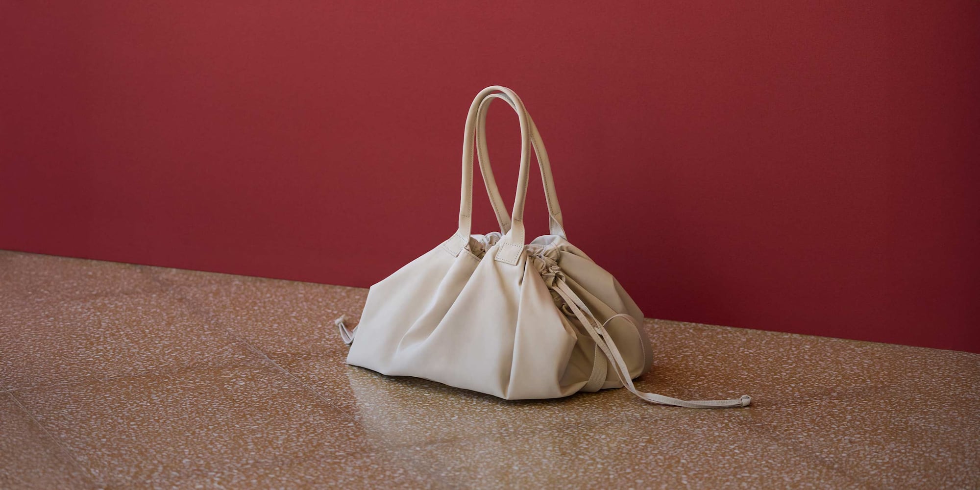 Sac à cordon beige posé au sol