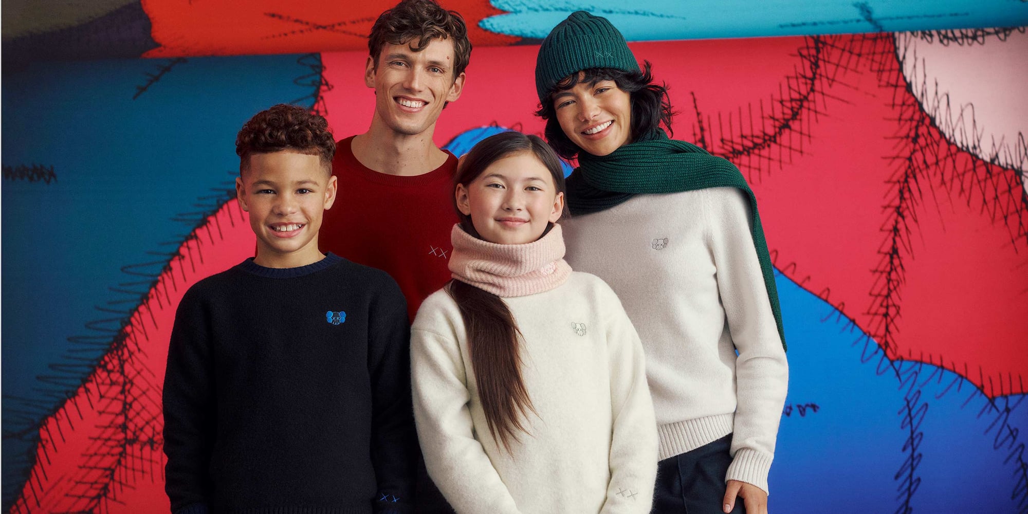 two adults and two children wearing KAWS WINTER knitwear by UNIQLO