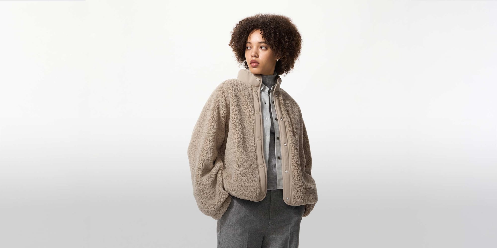 model wearing Fleece Stand Collar Jacket in beige with grey trousers