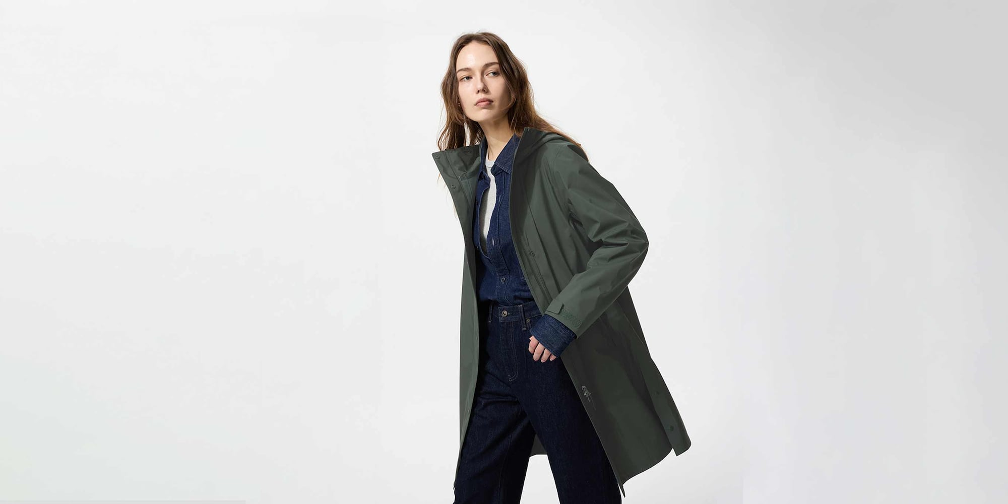 model wearing BLOCKTECH Coat in dark green with a denim shirt and jeans