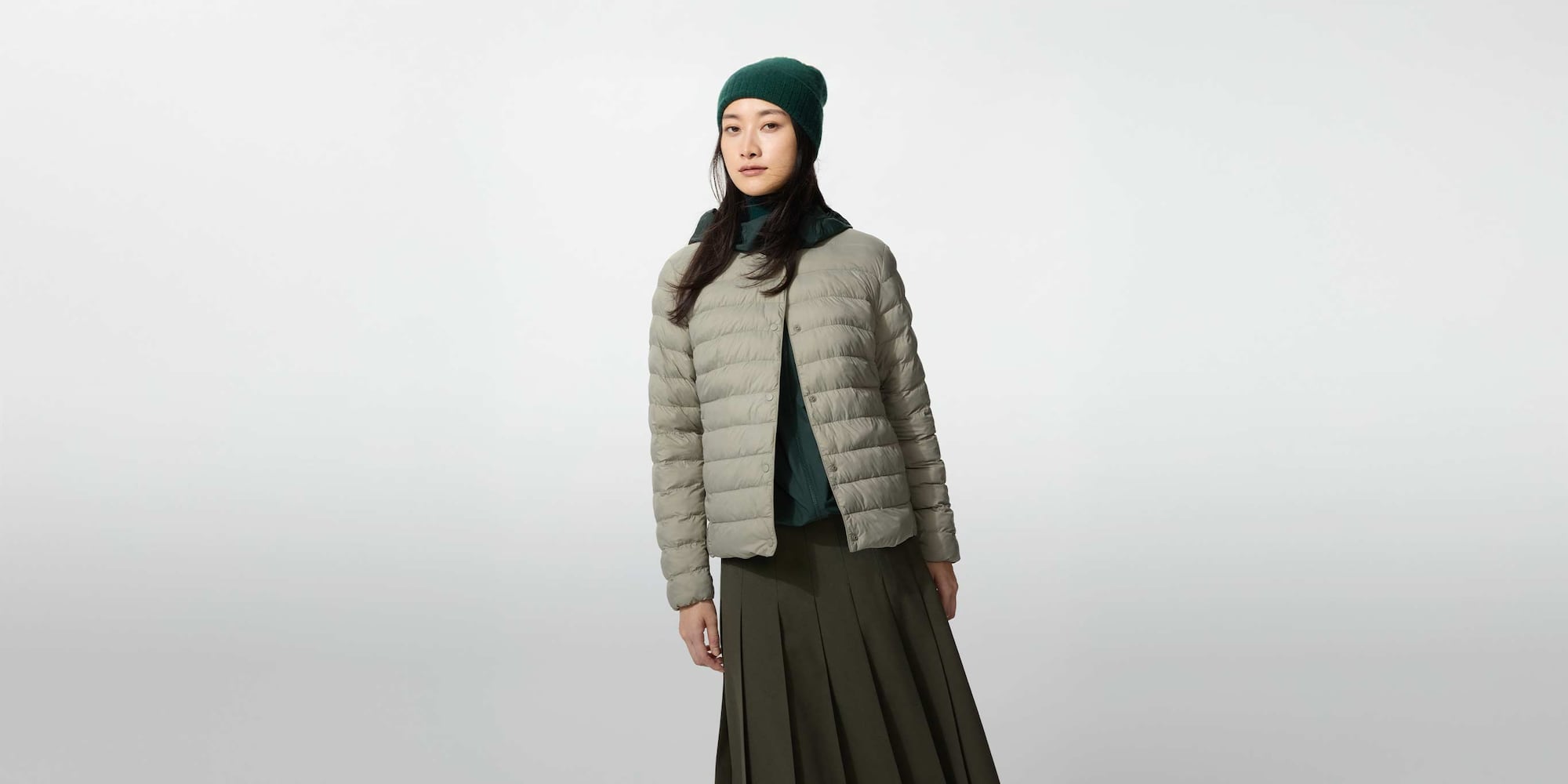 model wearing PUFFERTECH Compact Jacket in grey with a green beanie and grey skirt