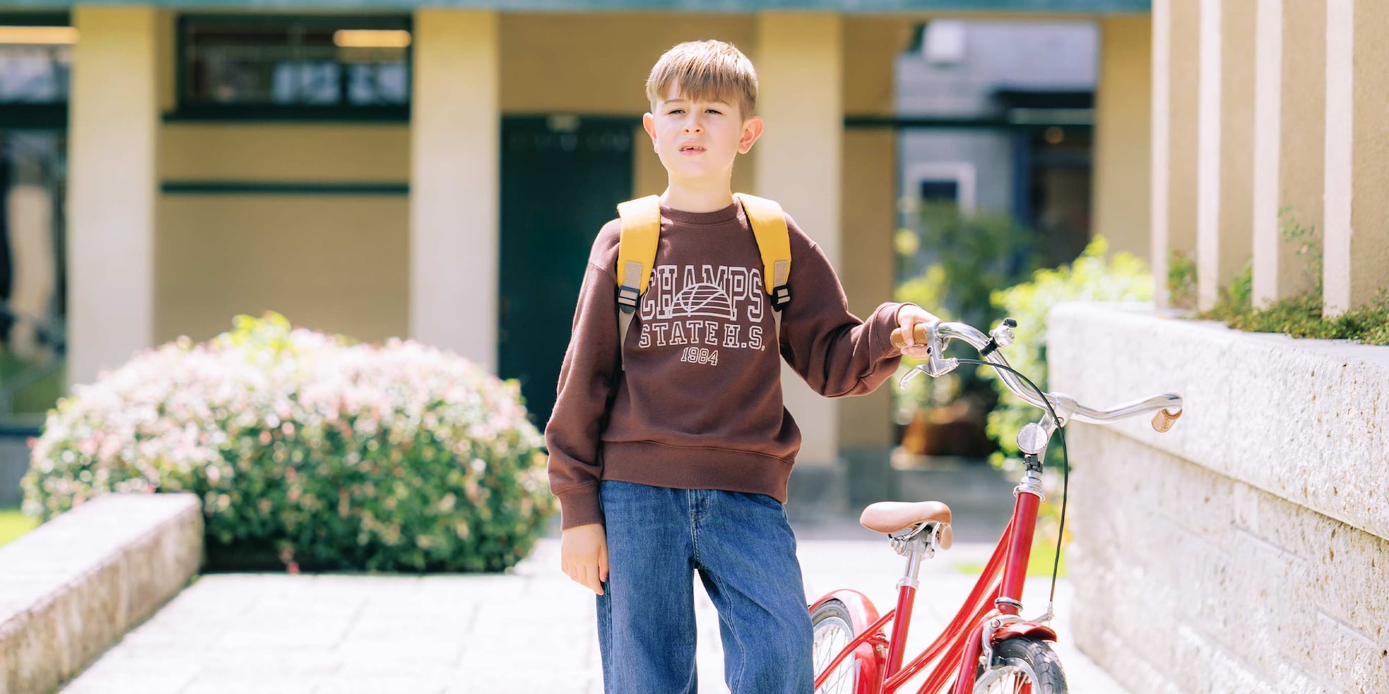 Model trägt ein dunkelbraunes Ultra Stretch Sweatshirt mit einem Retro-Grafikdesign.