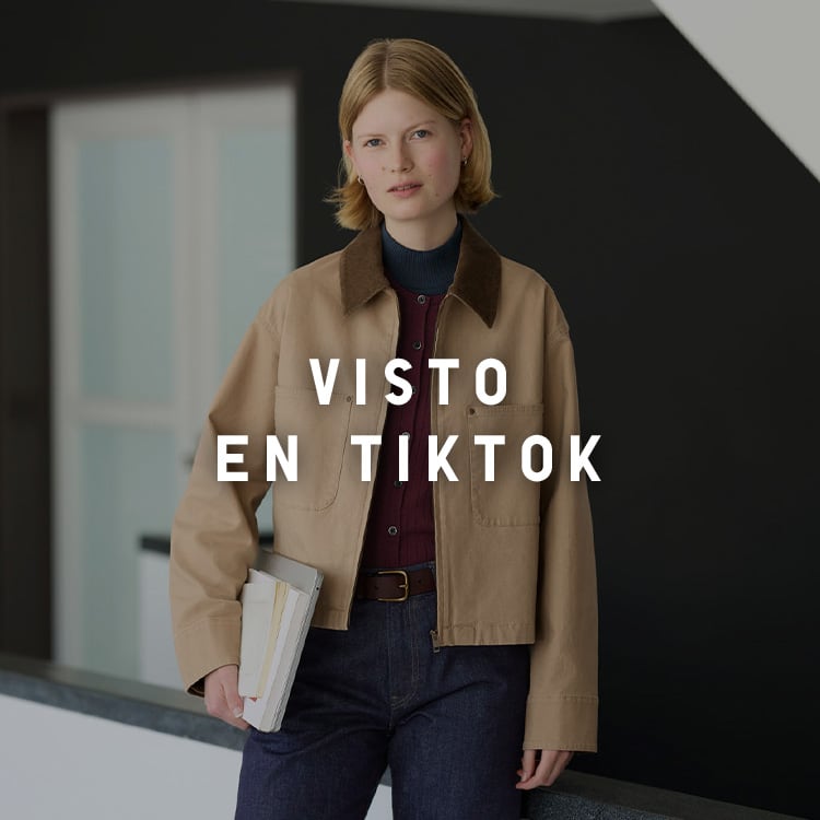 Mujer con chaqueta beige y vaqueros oscuros