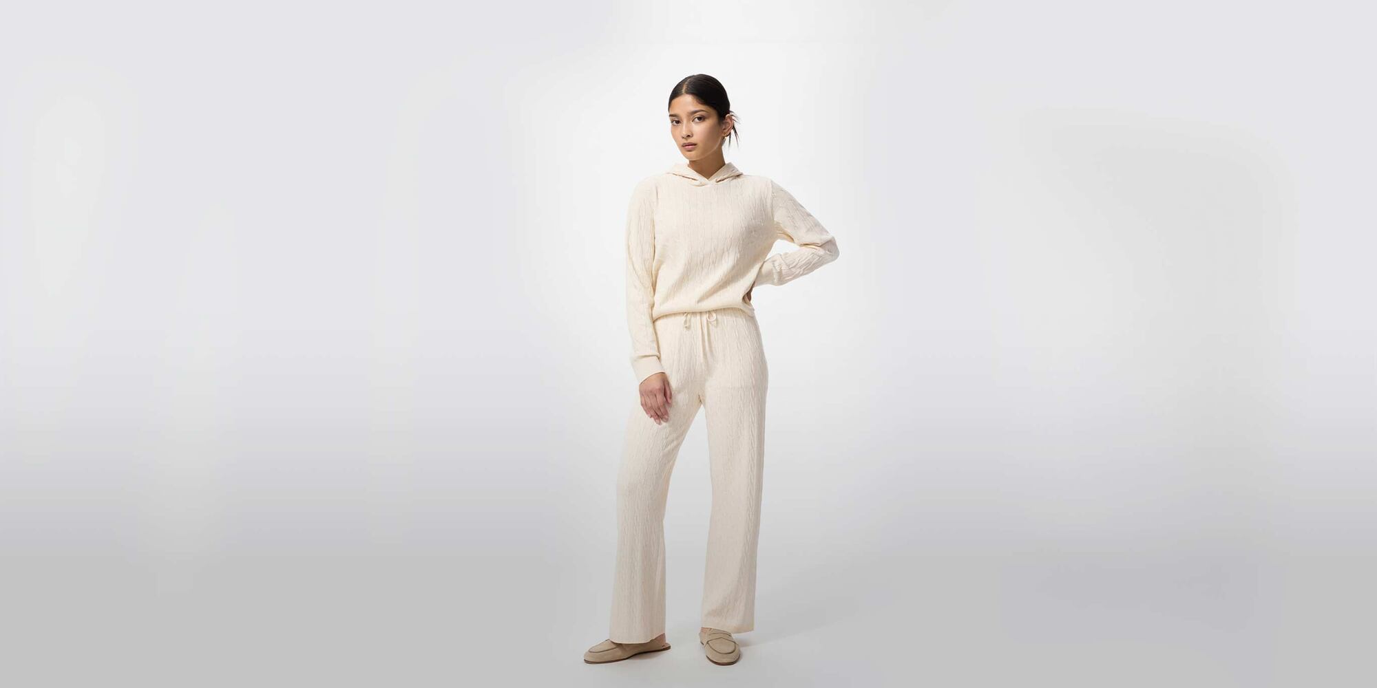 model wearing Washable Knit Cable Hoodie in off white with matching trousers and beige loafers