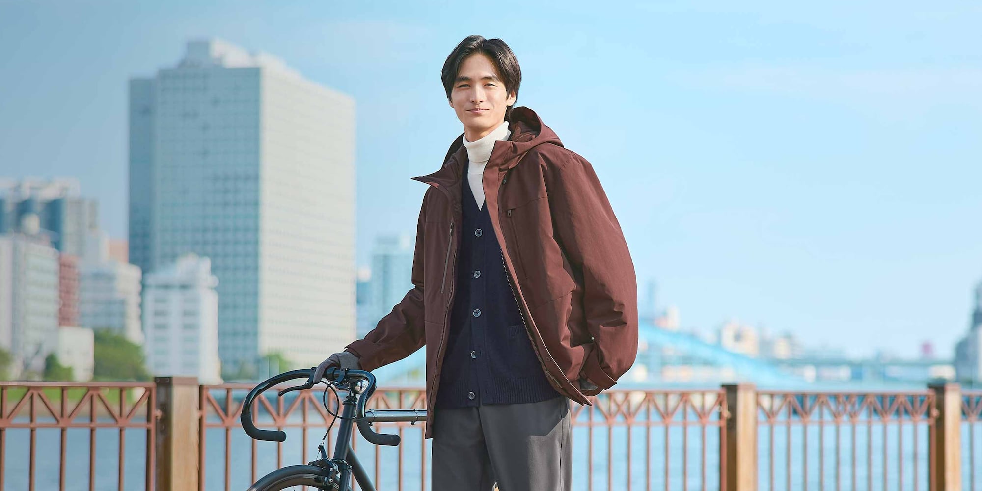 model wearing a khaki Hybrid Recycled Down Parka over a camel shirt and white T-shirt, with dark brown trousers