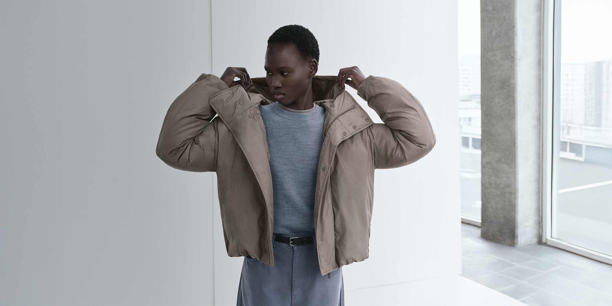 model wearing PUFFERTECH Parka in brown over a grey knit and trousers