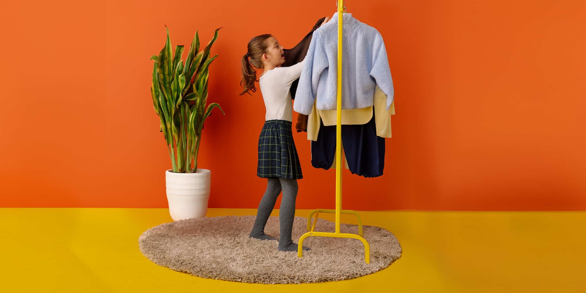 model wearing HEATTECH Knit Tights in grey with a navy checked skort and white top